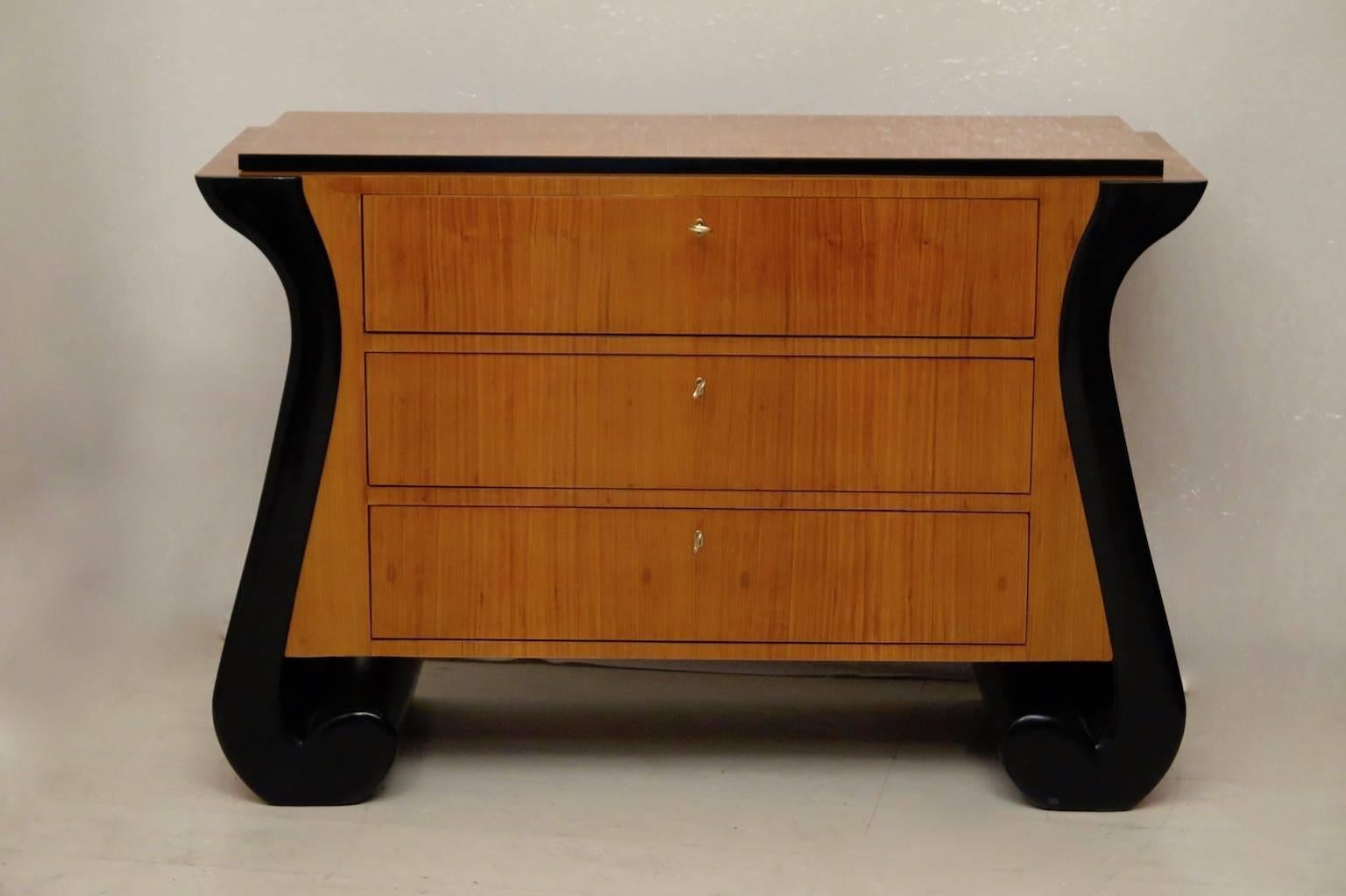Special design for this Art Deco dresser. All veneered in cheerywood, with finishing the sides of the drawers blacks lacquered. Three very spacious drawers. Very beautiful the big black commas simulating the legs.