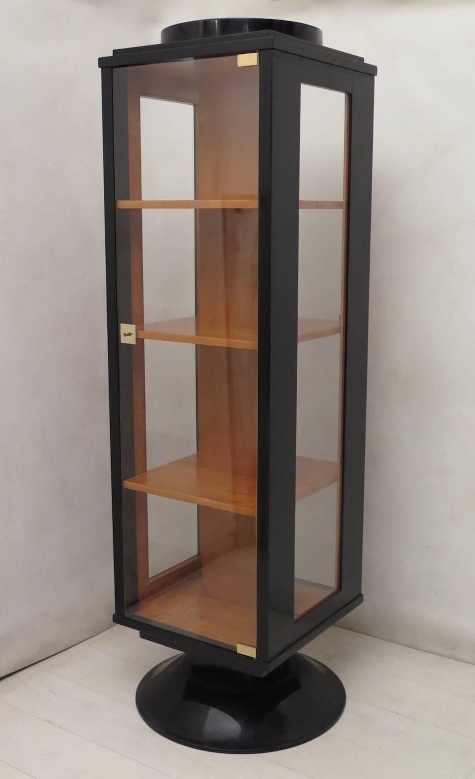 Pair of distinguishing Art Deco showcases, for their narrow and high design, and for the fact of being richly finished even internally.

All polished in black lacquer with a richly maple veneer inside. It has two glass doors that allow access