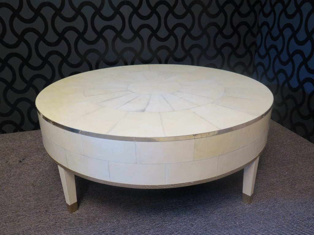 1940 Art Deco sofa table. This sofa table has a very luxurious appearance, due the use of not common materials.  

Completely covered in parchment leather or goat skin with polished brass finishes. The parchment leather on the top forms a drawing,