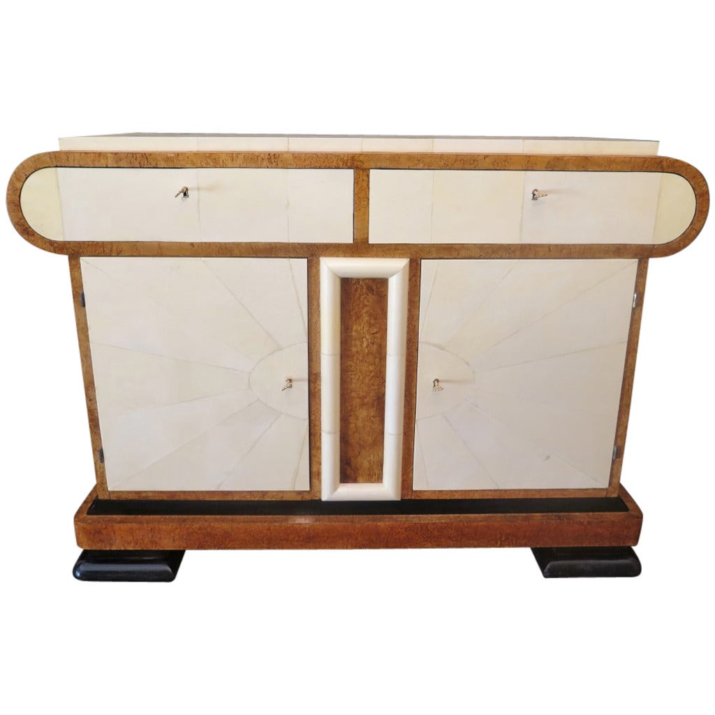 Italian Art Deco sideboard, its design is very particular, as you can see from the photos.

All veneered in white birchwood and covered in parchment leather or goat skin. Sideboard composed of a high part with the top and two drawers below, and a