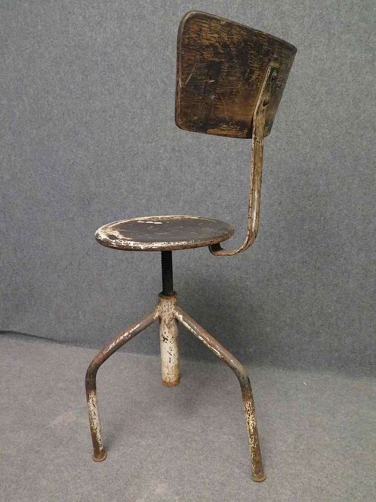 Tabouret en métal du milieu du siècle. 

Le tout en métal laqué blanc usé par le temps. Le siège est rotatif et peut être relevé et abaissé selon les besoins. Il possède trois pieds pliés qui se rejoignent au milieu ; ils sont soudés à un tube qui