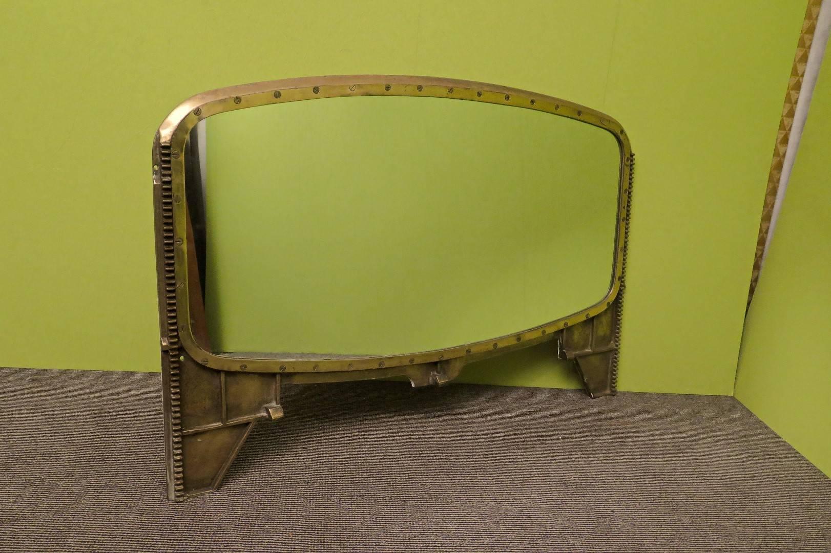 Italian wall mirror from 1930, coming from an old abandoned ship.

This all-encompassed brass structure forms a frame around it, with the lower part forming two large appendices on the sides, so that it can be placed on a piece of furniture or other