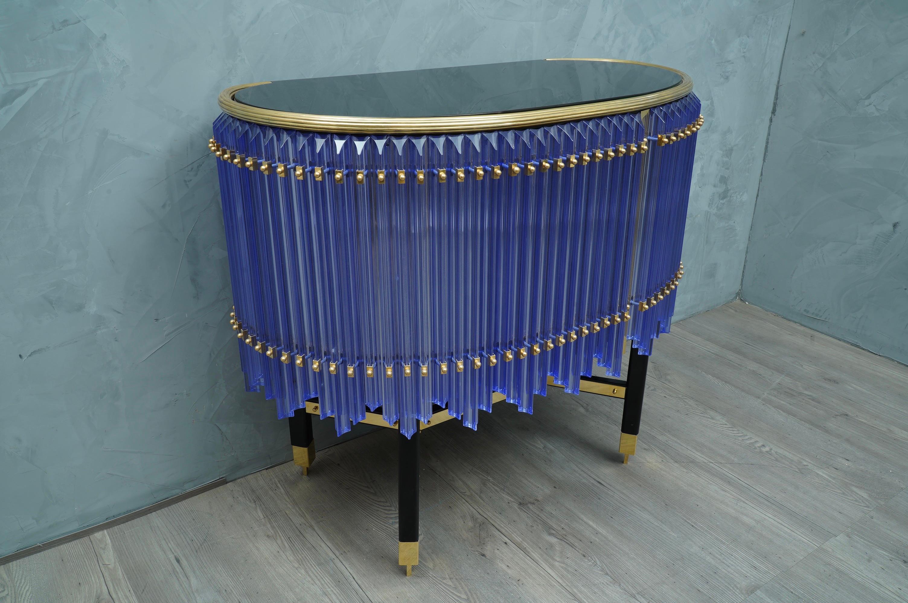 Precious handwork of a beautiful periwinkle color enhanced by polished brass finishes, exalting both for its precious materials and for its shape.

The sideboard / bar has a wooden structure, with an oval shape squashed in the back side. The body of