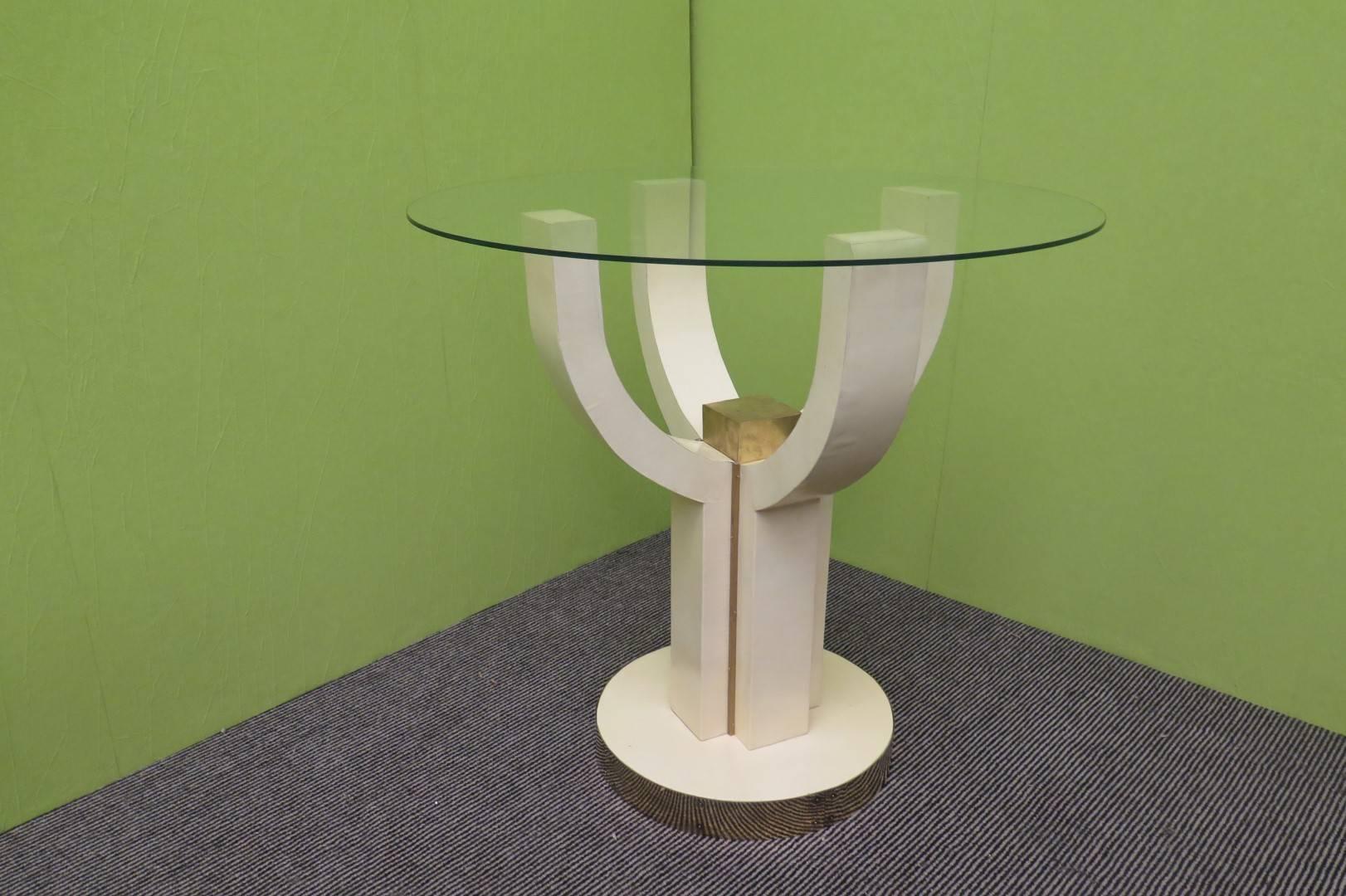 Simple, but really elegant side table; all covered in parchment and brass finishing, with a glass top.
