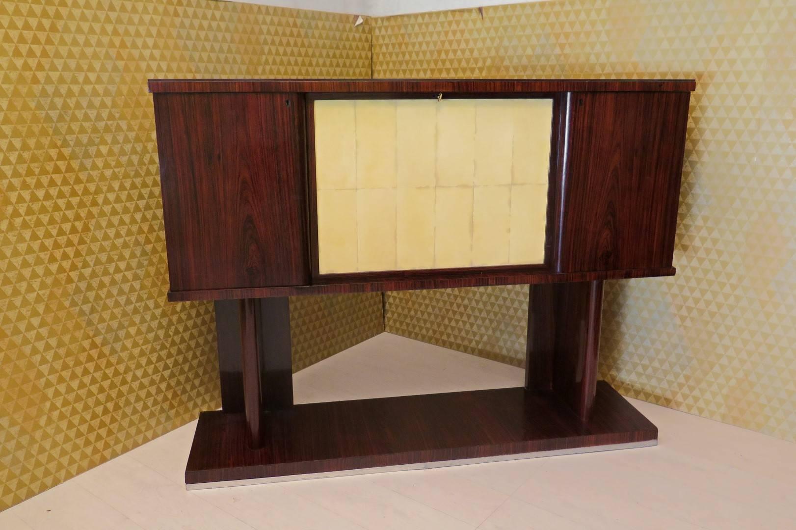 Dry bar in rosewood veneer, with central door in parchment and glass top red bordò, internally lined everything in mirror with glass shelves and wood.
Very very beautiful piece of furniture and have much effect.