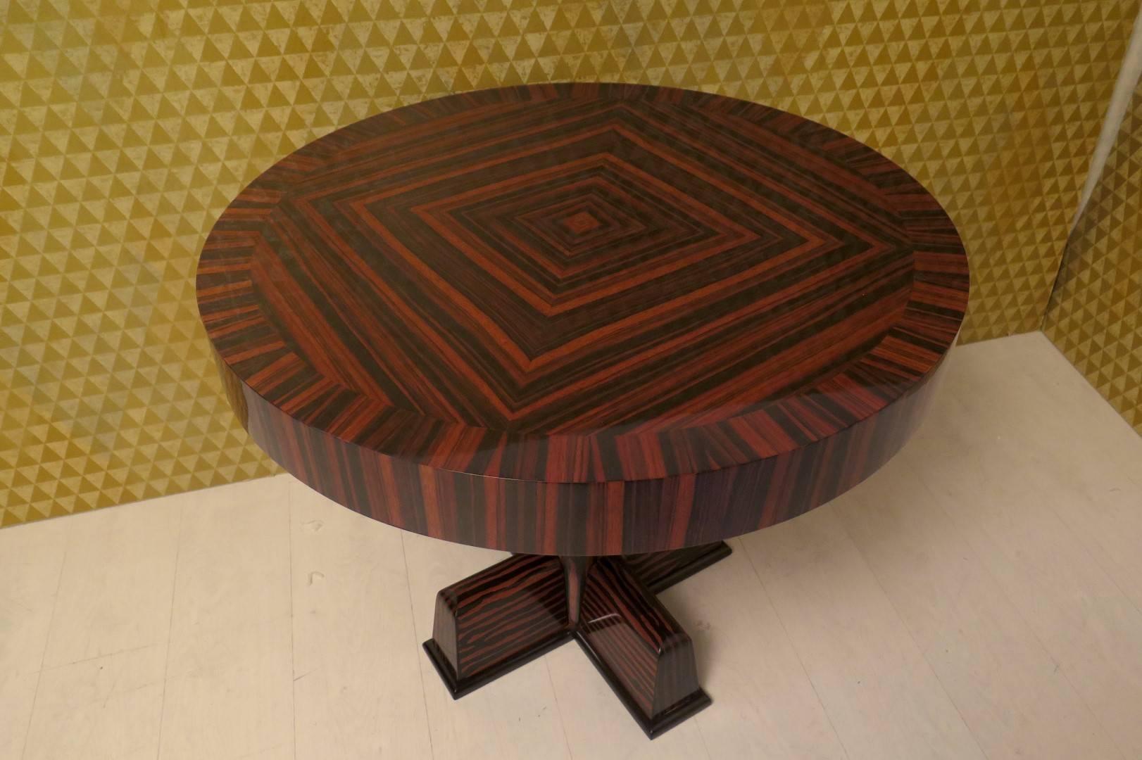 Side table veneered in Macassar ebony, special design of the veneer on the top, the middle leg very nice, with a large sphere and four big feet
to the sides of a beautiful sofa with a table lamp on, why not.