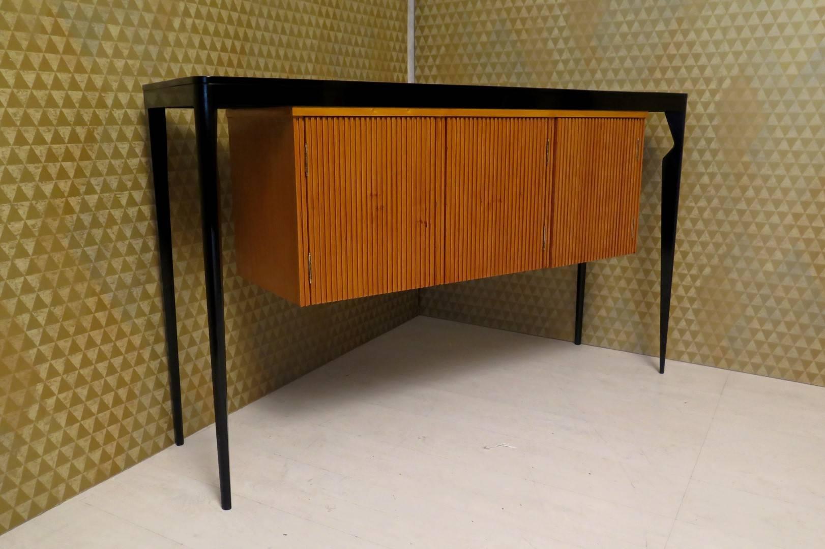Glamorous sideboard 1940s, top and legs lacquered black. Central part in cherrywood with three doors. Very very particular form of this sideboard and its design, fine its four legs, and a central body 