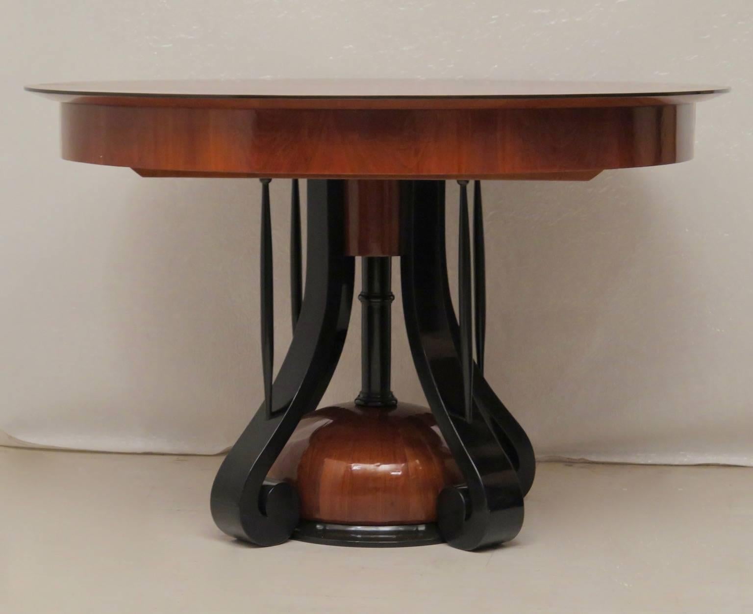 An important Biedermeier table, with a big round top and a very particular leg. The tabletop is veneered with a beautiful cheerywood, with parts forming the segments of the pie. The central leg is formed by a semi orb veneered in cheerywood and by