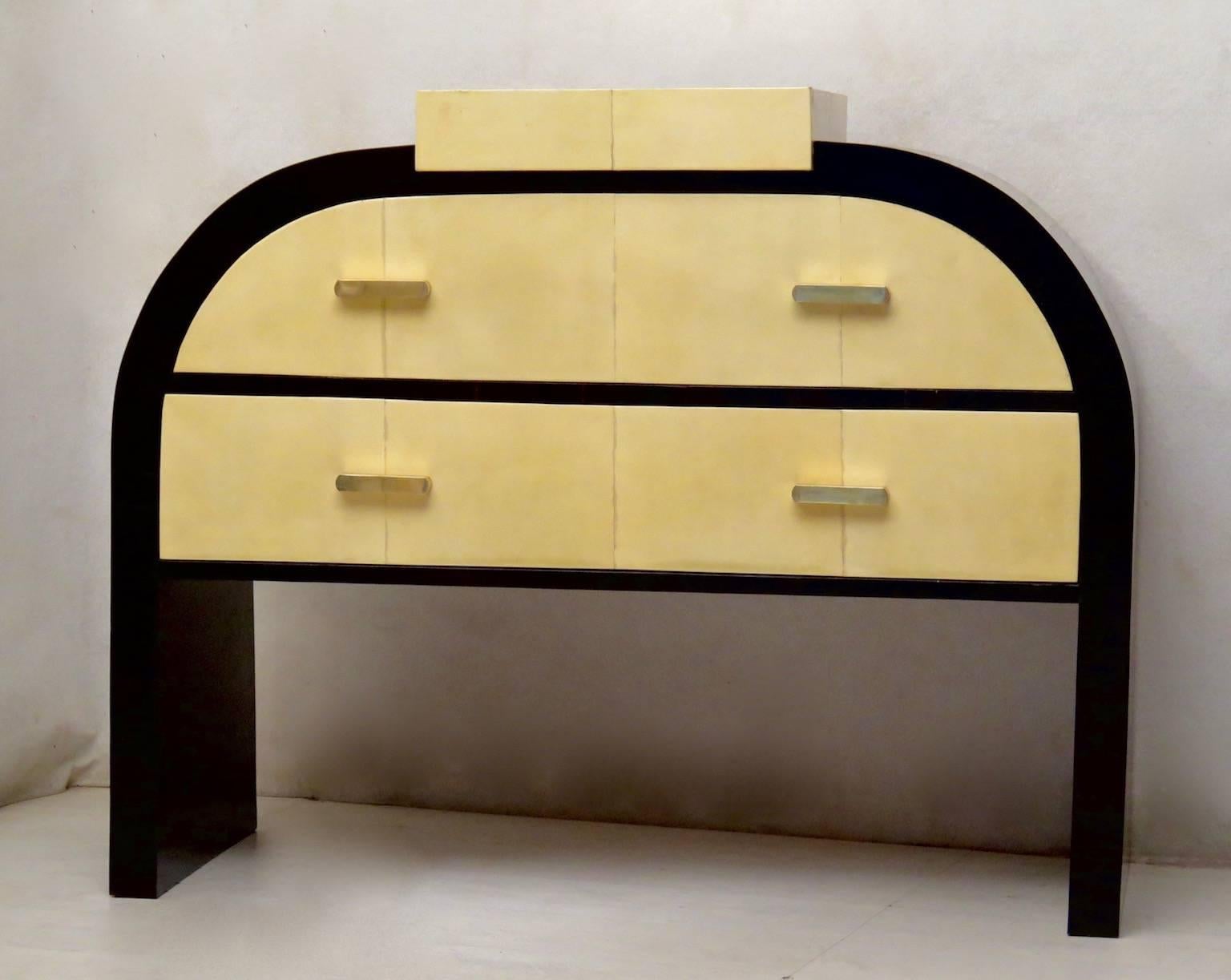 Sinuous shapes for this fine piece of furniture from the first half of the 20th century.

All veneered in ebony Macassar wood, with the two drawers and little top covered in goat skin or parchment leather. The dresser top can be pulled up. As you