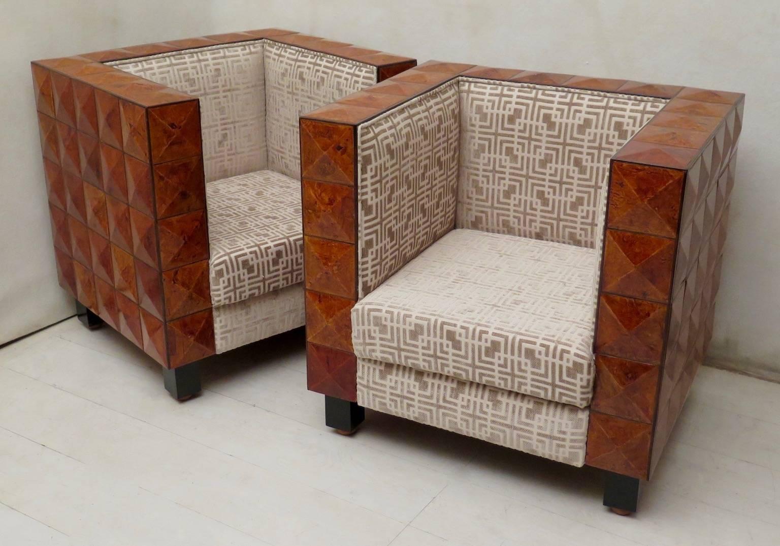 Pair of ash wood veneered armchairs. Its design is very nice because its made up of small pyramid trunks. Four squared black feet with rounded support make sure that the armchair does not fall to the ground, but is slightly raised. The fabric with