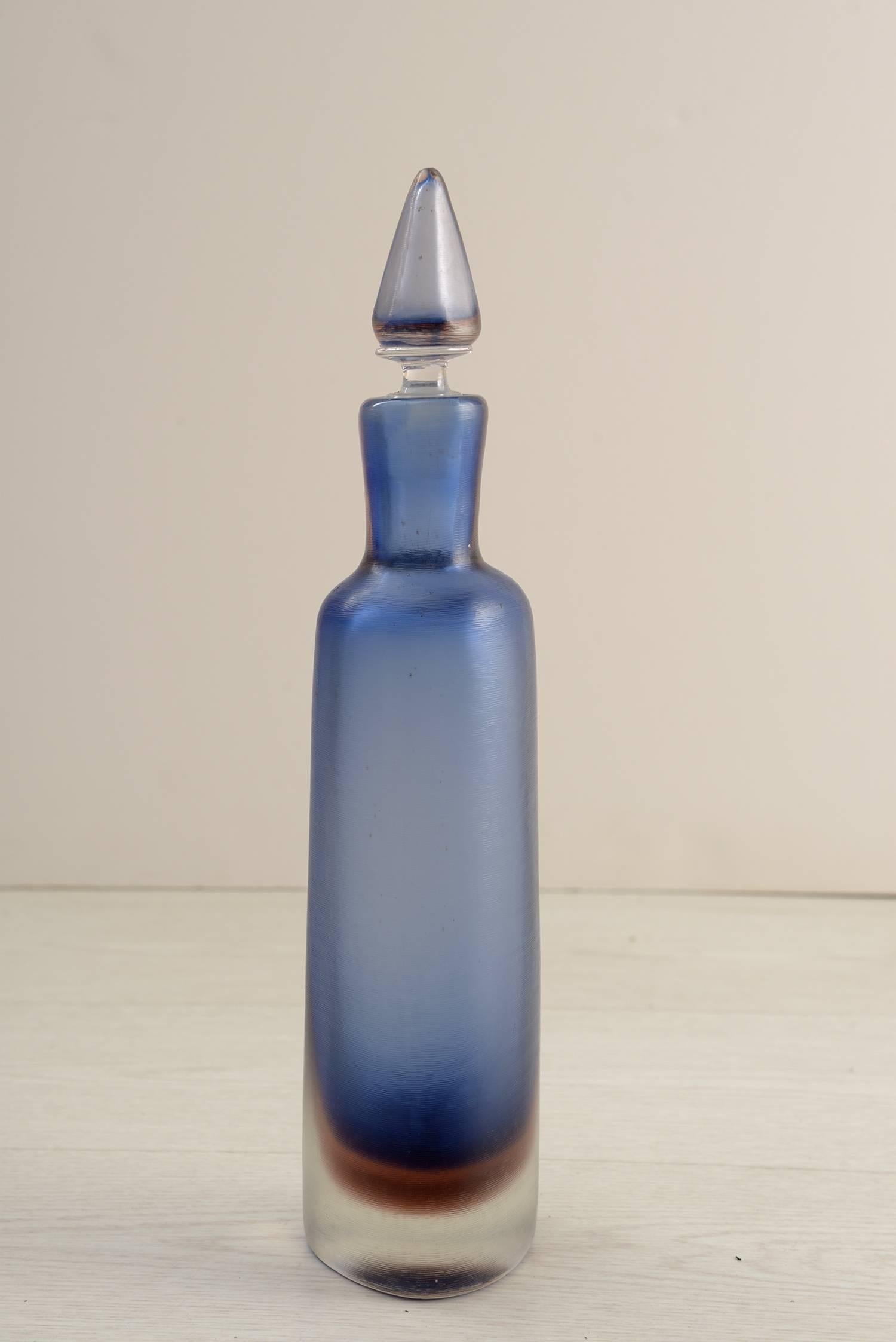 Bleu and brown overline colored bottle with soft engraved by weeks surface.
Triangular section.
Designed by Paolo Venini for Venini Murano in the 1956. Acid signature- Venini Murano Italia. Published.

1957 Exhibition in Hannover.
1960
