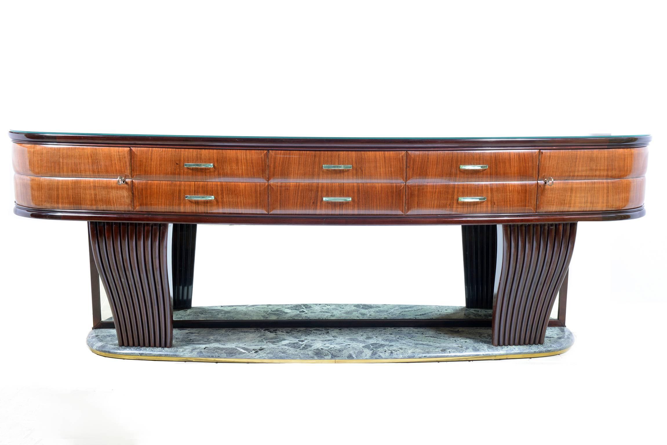 Demilune shaped rosewood sideboard, six drawers with crystal bevelled and mirrored handles, two curved doors.
Interiors on maples wood.
The top is in black glass and the base on an alp marble rimmed on brass on the floor part.
Two grooved curved