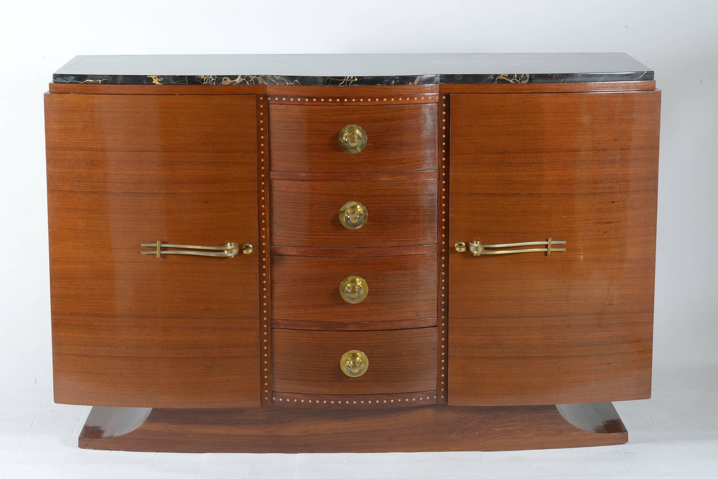 Two front curved doors and four curved drawers in precious exotic wood.
Crystal sphere handles on the drawers and brass handles and keys for the side doors.
Inlaid white bakelite decoration around the drawers.
Portoro marble top and moustache shaped