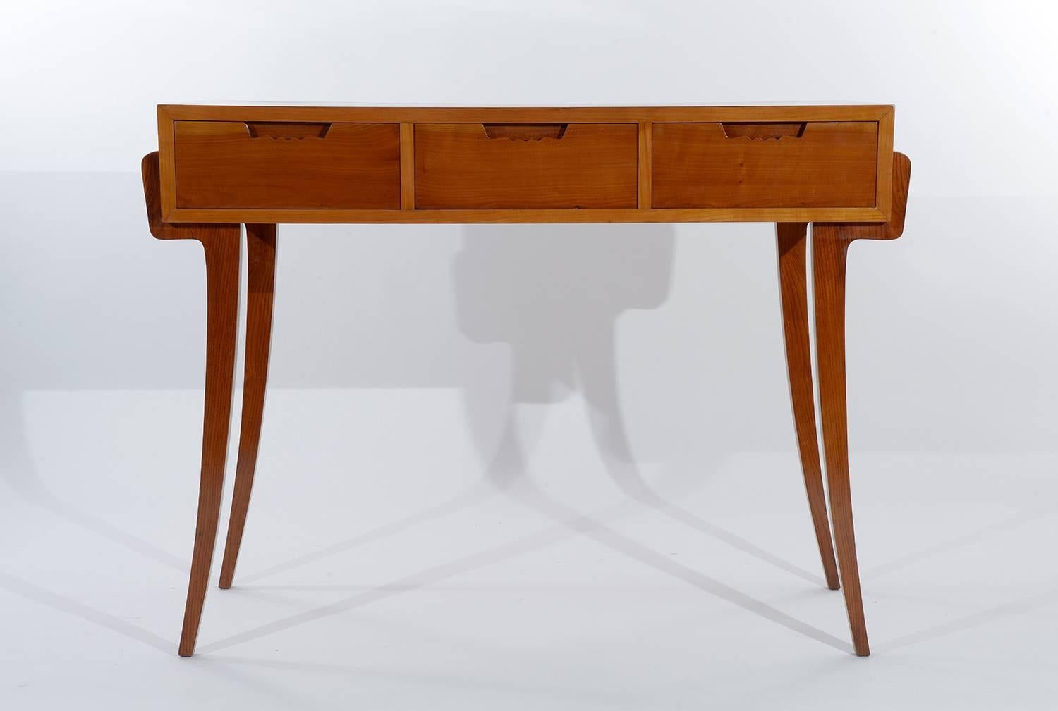 Four curved and slender legs and tree drawers with sculptured handles in the cherrywood.
This little console desk is finished on the back, can be put in the center of a room or against the wall.