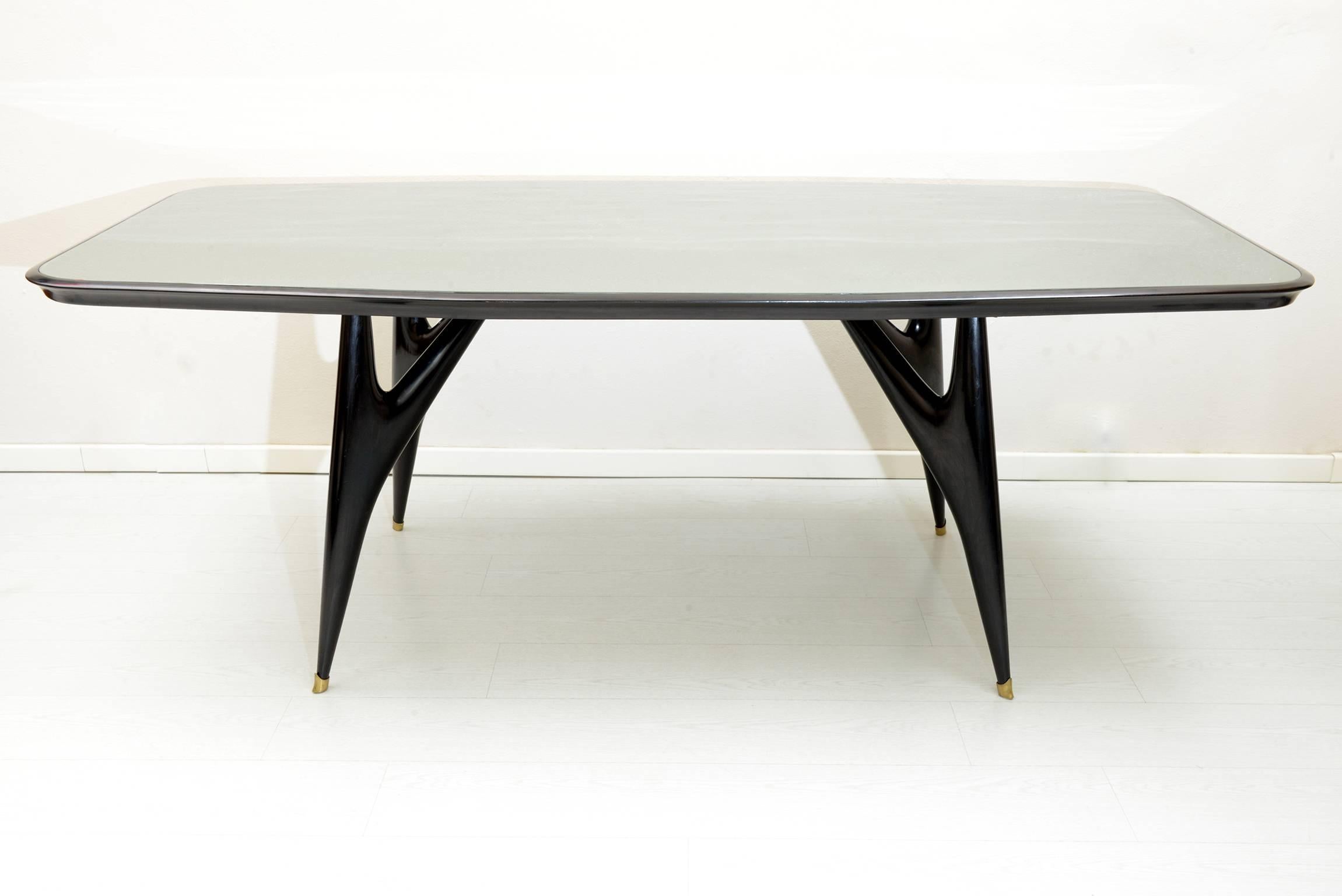 Four slender black laquered solid wood sculptured legs with brass feet details.
Glass encased octagonal top.