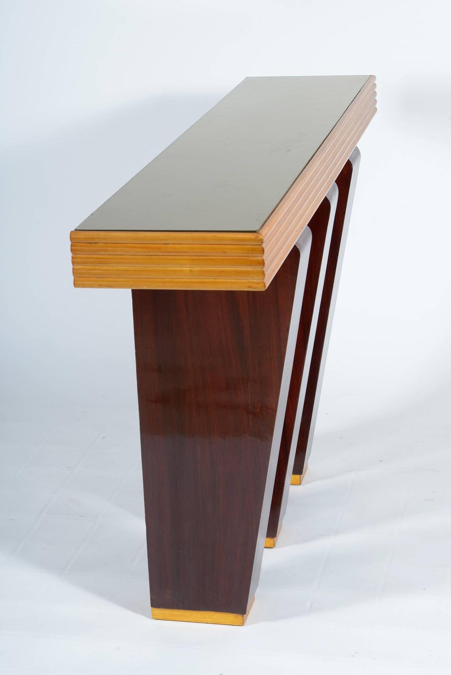 Rationalist Italian console in maples wood and amarant, three inclined legs support a plan with grooved edge.
Golden glass top.
Designed by the Architect Cesare Scoccimarro, circa 1938
Similar example is published in the book: Arredamento Moderno