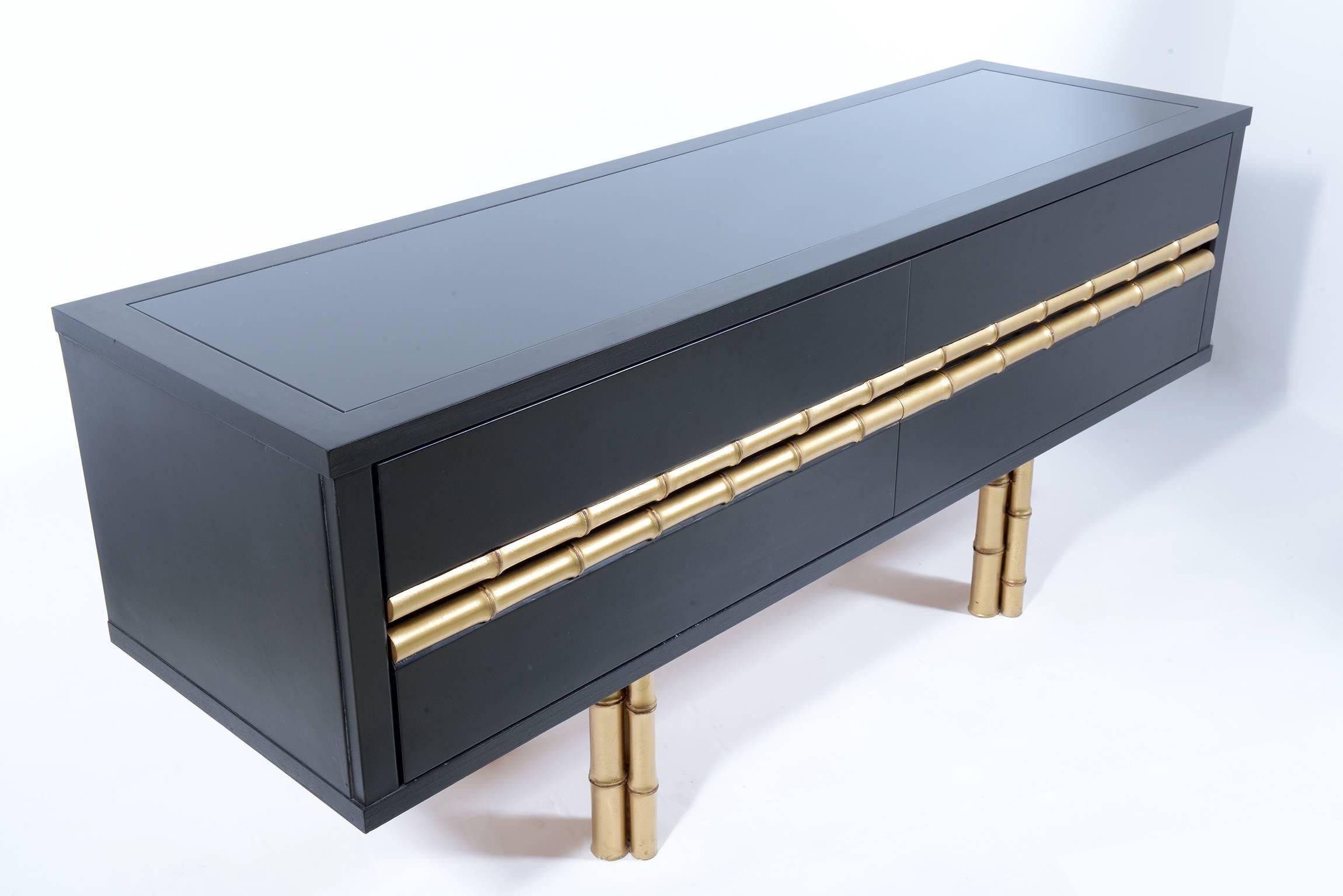 Black lacquered wood and handles and feet bamboo shaped and gold.
Four-drawer.
Black glass top.
  