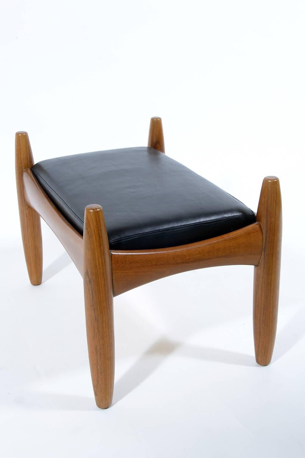 Soli sculptured teak wood and black leather upholster.
