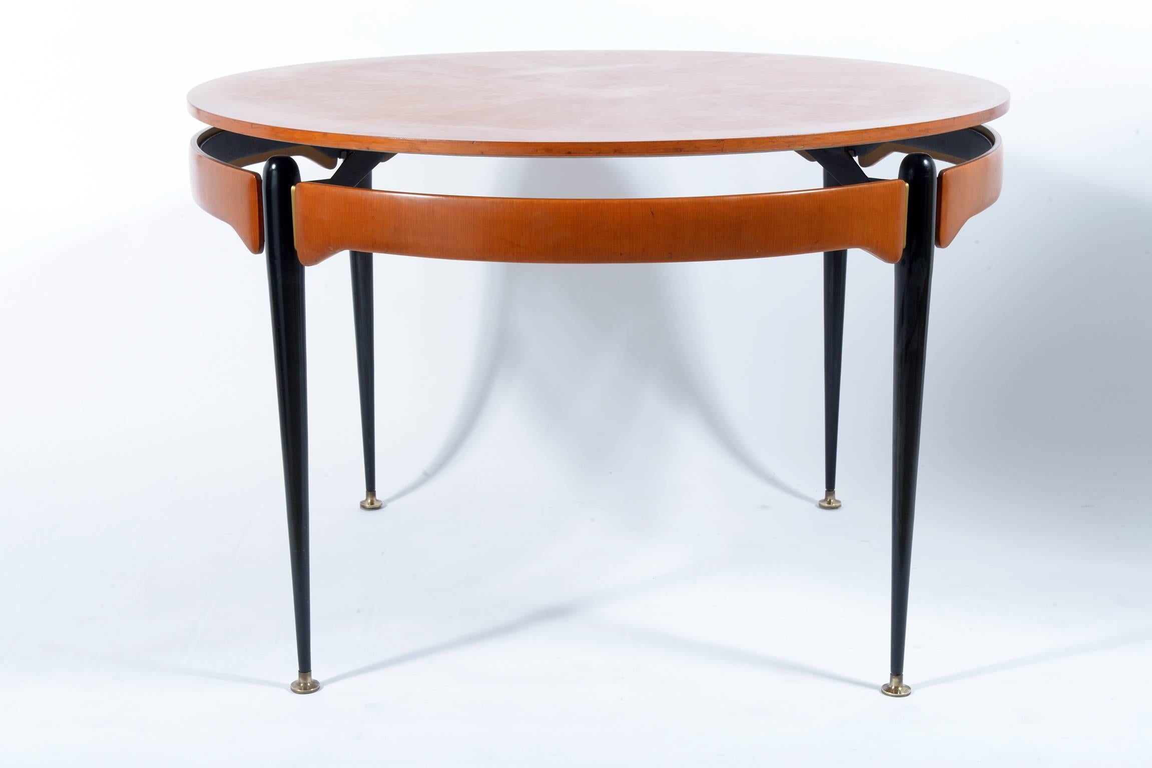 Round Italian table with radially walnut top, black metal legs and brass feet and details.
 