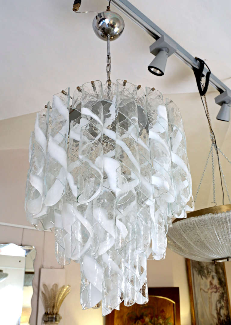 1960s chandelier by Mazzega Murano, many pendants in transparent and white milk blown glass.
Seven bulbs inside.
The chain could be shortened, to let less higher the chandelier.
Murano, Venice, Mid century modern.