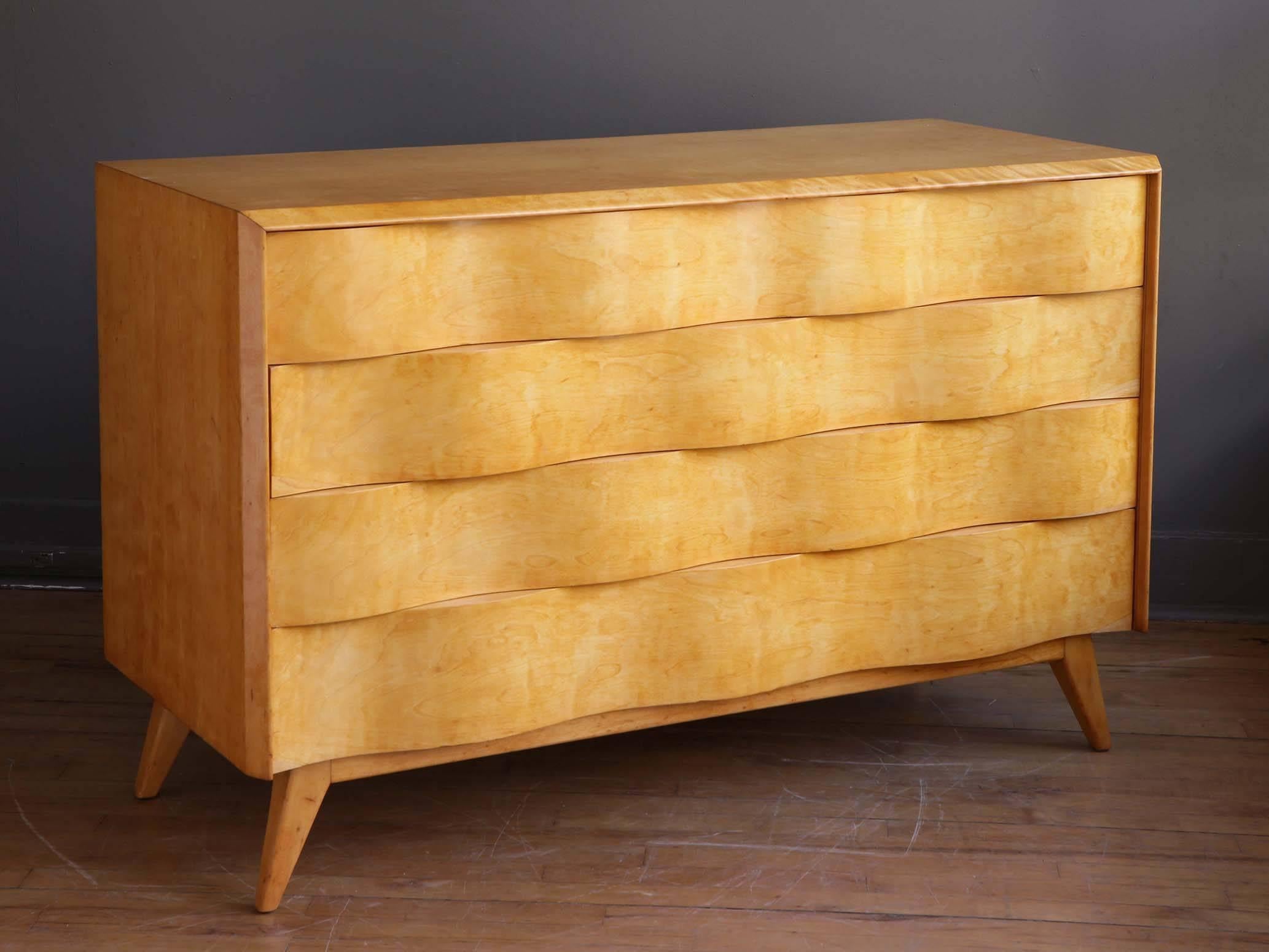 A sculptural birch chest by American designer Edmond Spence, circa 1950s. Featuring four spacious drawers with undulating wave fronts supported by flared feet. Manufactured in Sweden.