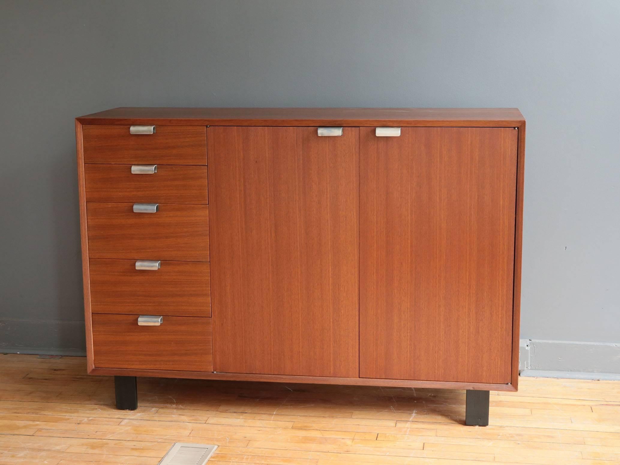 A beautifully restored primavera cabinet designed by George Nelson for Herman Miller, circa 1950s. Featuring a bank of five graduated drawers and two cabinet doors that open to reveal additional storage drawers and adjustable shelves. Original 