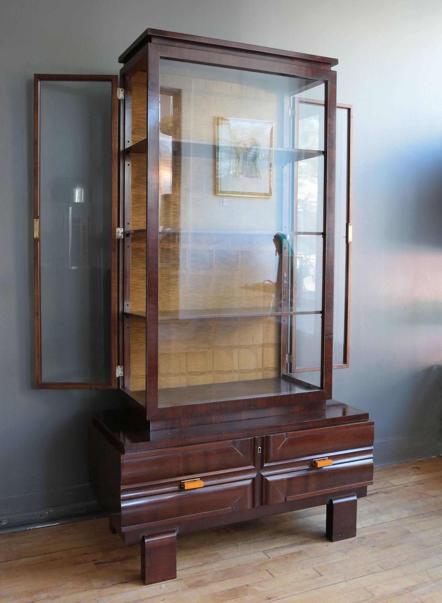 A beautiful Art Deco cabinet manufactured by the Hungarian cabinetmaker Károly Lingel, circa 1930s. Featuring a walnut base with large drawer supporting a walnut display cabinet with fixed glass front and glass doors on each side. Back of cabinet