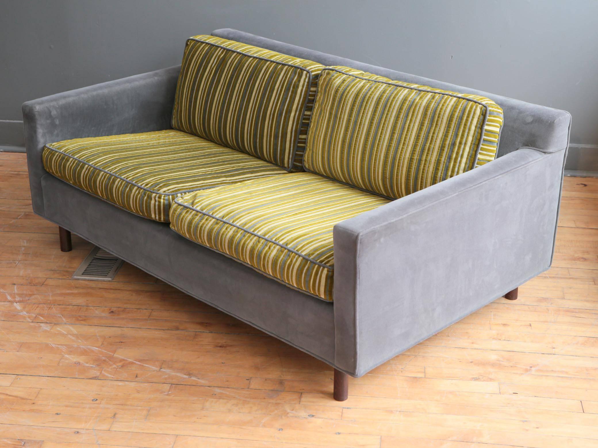 A nicely scaled Mid-Century Modern loveseat very much in the Style of American designer Harvey Probber, circa 1960s. Featuring a classic form with two loose seat cushions and two loose back cushions. Supported by cylindrical rosewood legs.
