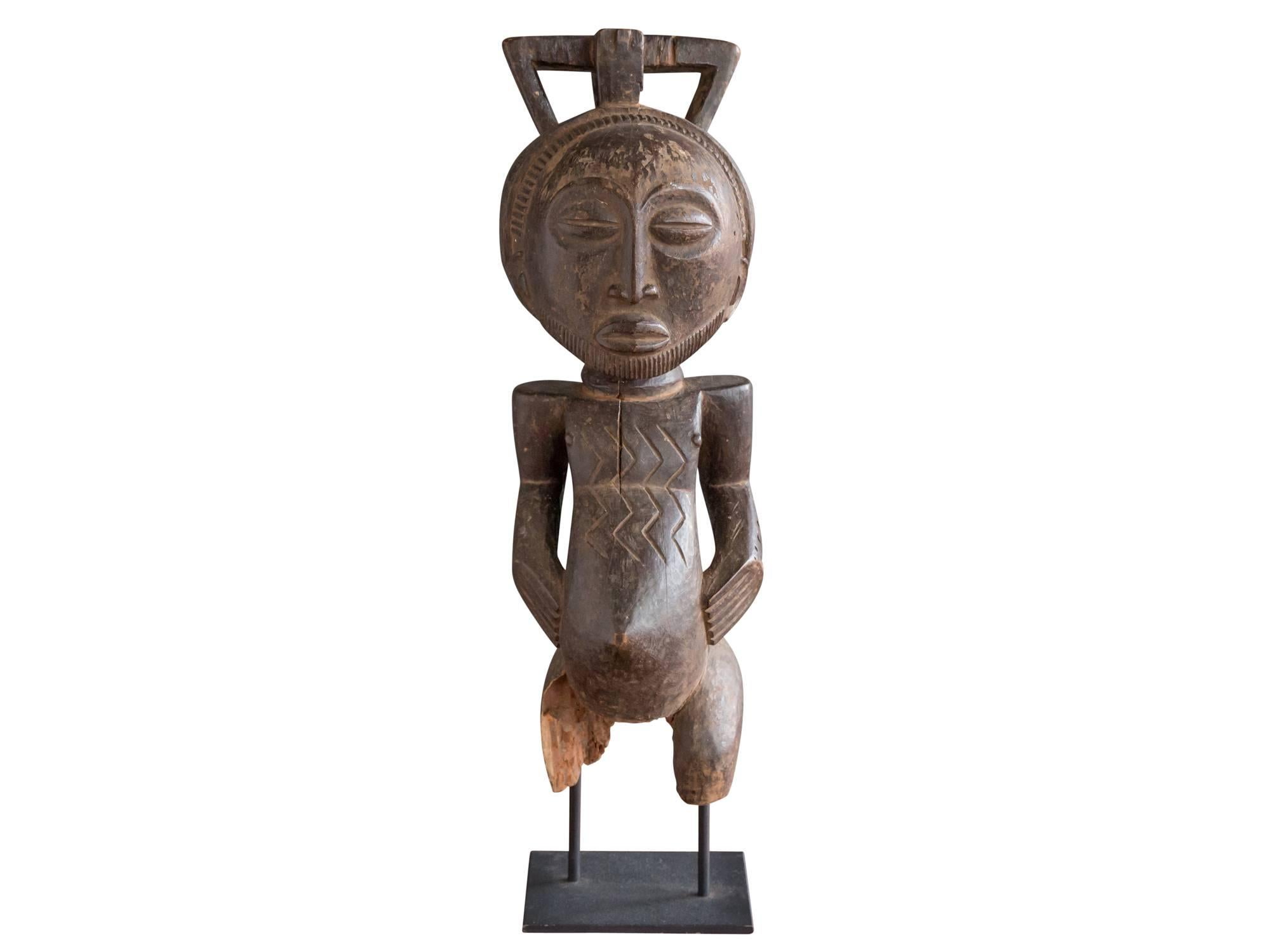A hand-carved wood singiti or ancestor figure from the Hemba people, Democratic Republic of Congo. Most likely from the mid-20th century. Featuring a sensitively rendered face with serene expression and grooved beard. Pierced, four-lobed hairstyle