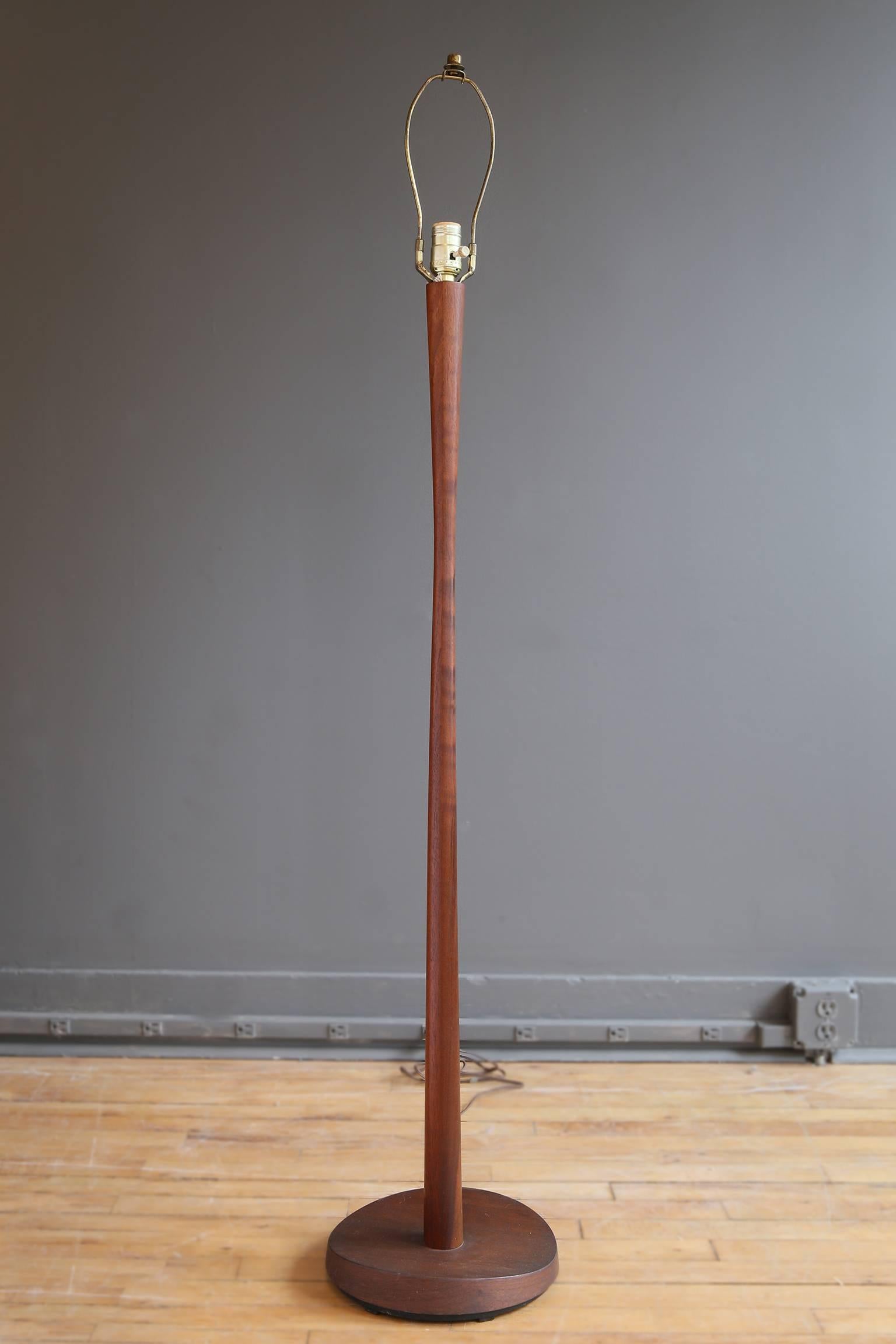 A teak floor lamp by the Laurel Lamp Co., circa 1950. Featuring a flared shaft and sculptural circular base.