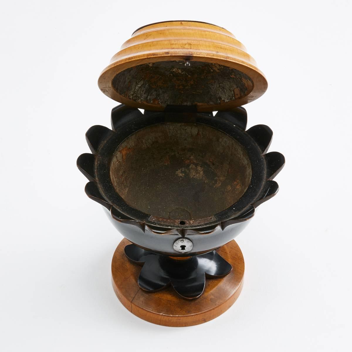 19th century boxwood and ebonized base tea caddy in the form of a flower with a dome glass panel which holds a small bouquet of dried flowers.

The interior is all original with remnants of a lead lining 

date circa 1820.