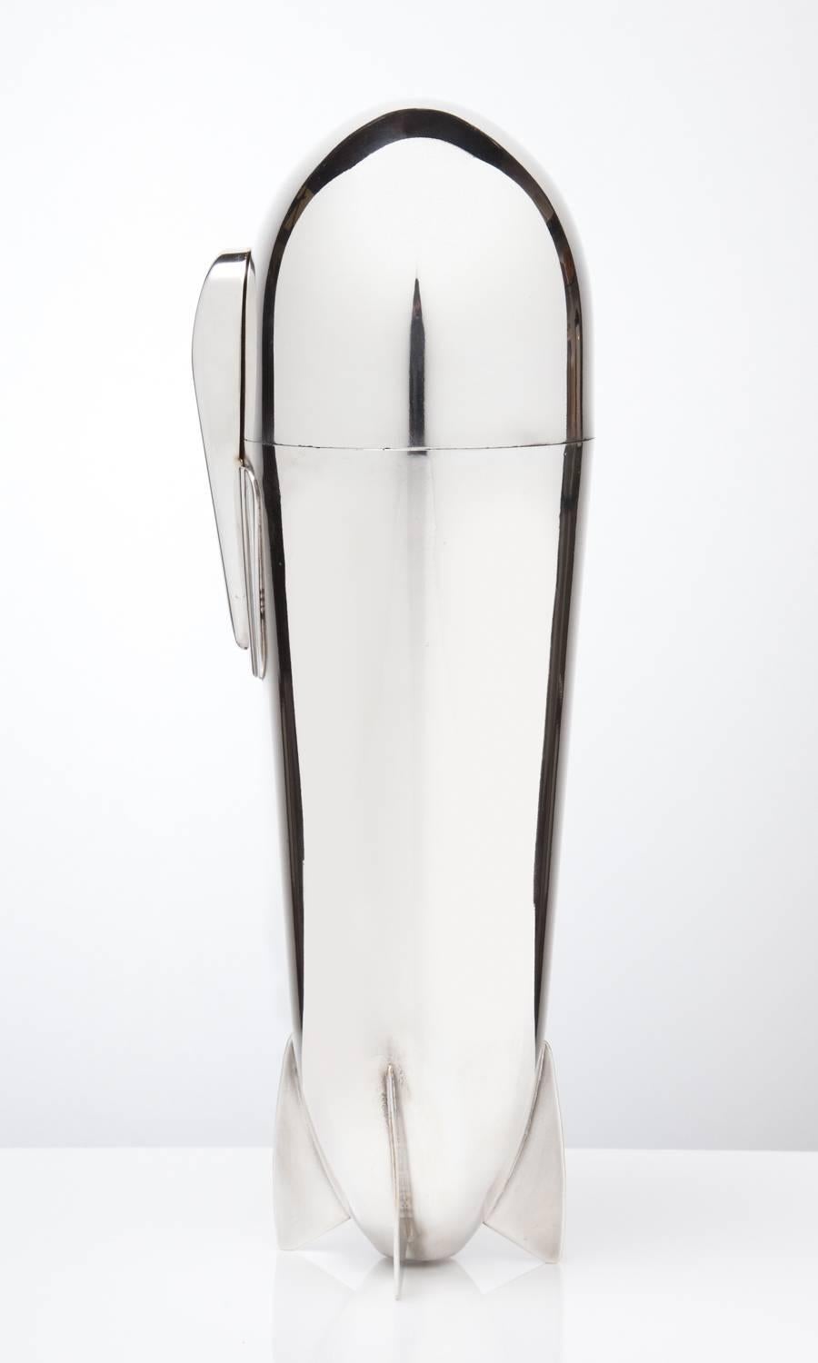Superb quality precision made & designed silver-plated Zeppelin cocktail shaker comprising a complete set of interior accessories including lemon sqeezer, olive dish, flask, 4 cups, 4 spoons corkscrew, all with guilded interiors, origin Germany
