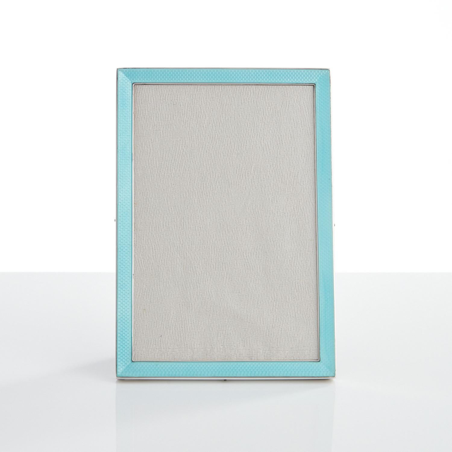 This great quality cast silver & enamel frame is in excellent condition.

The enamel has a translucent quality and the silver is marked sterling.

The back & easel support is covered in black velvet.

Dimensions are H 7” W 4 3/4” depth of