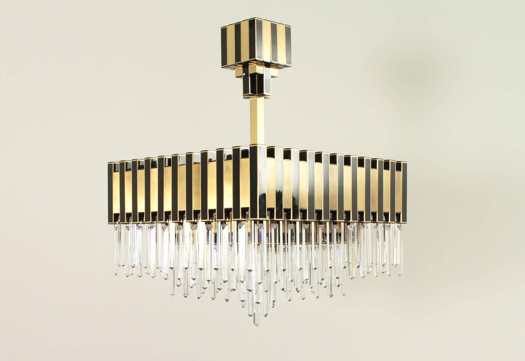 Large chandelier edited by BD Lumica, Spain, 1970s. Brass, lacquered brass and glass teardrops. The ceiling piece can be regulated in height, 16 bulbs.