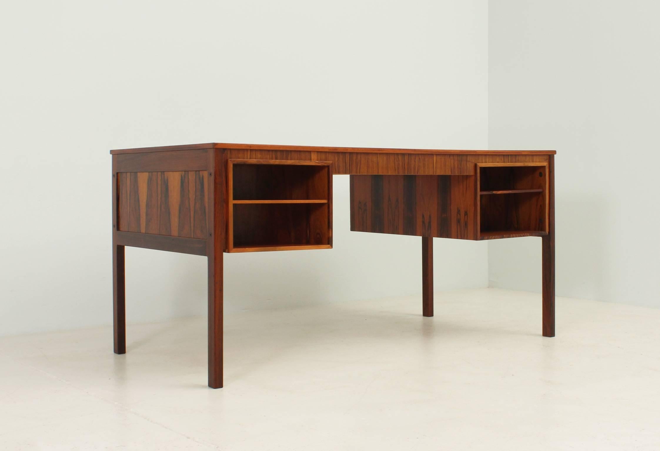 Desk in Rio rosewood designed in 1960s by Erik Wørts, Denmark. Three drawers, drop door and extension in the front side and two compartments with shelf in the backside.