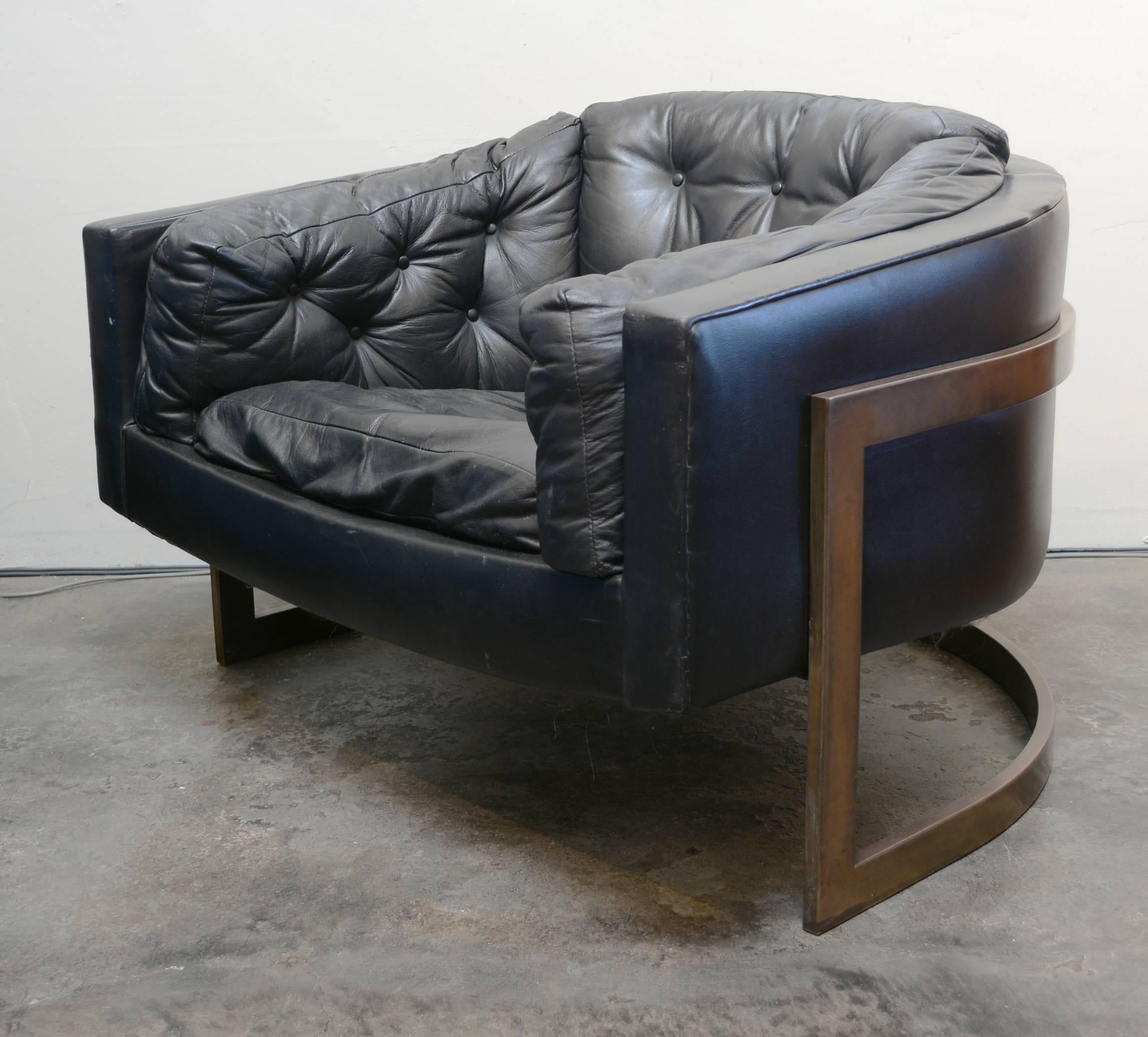 Large-scale chair designed by Jules Heumann. This chair has a bronze cantilevered frame with the seat in black leather. This is in original condition. There is some wear on the leather on some edges. The chair is comfortable but the seat webbing may