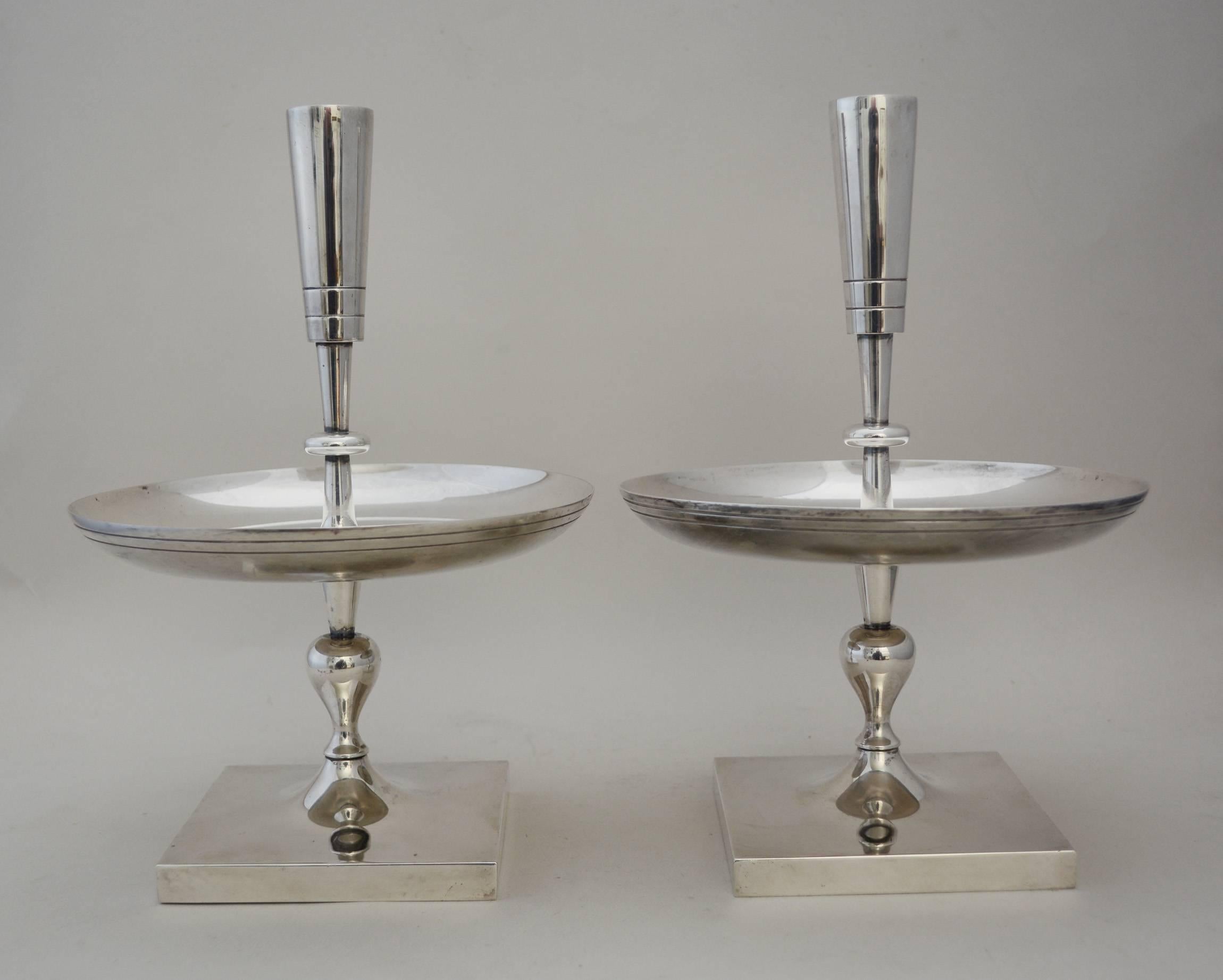 Silver plate candleholders from the Oneida Heirloom 700 line. This line consisted of Tommi Parzinger designs acquired from Dorlyn Silversmiths. There are some areas of slight pitting to the silver plate. One has a small dent.