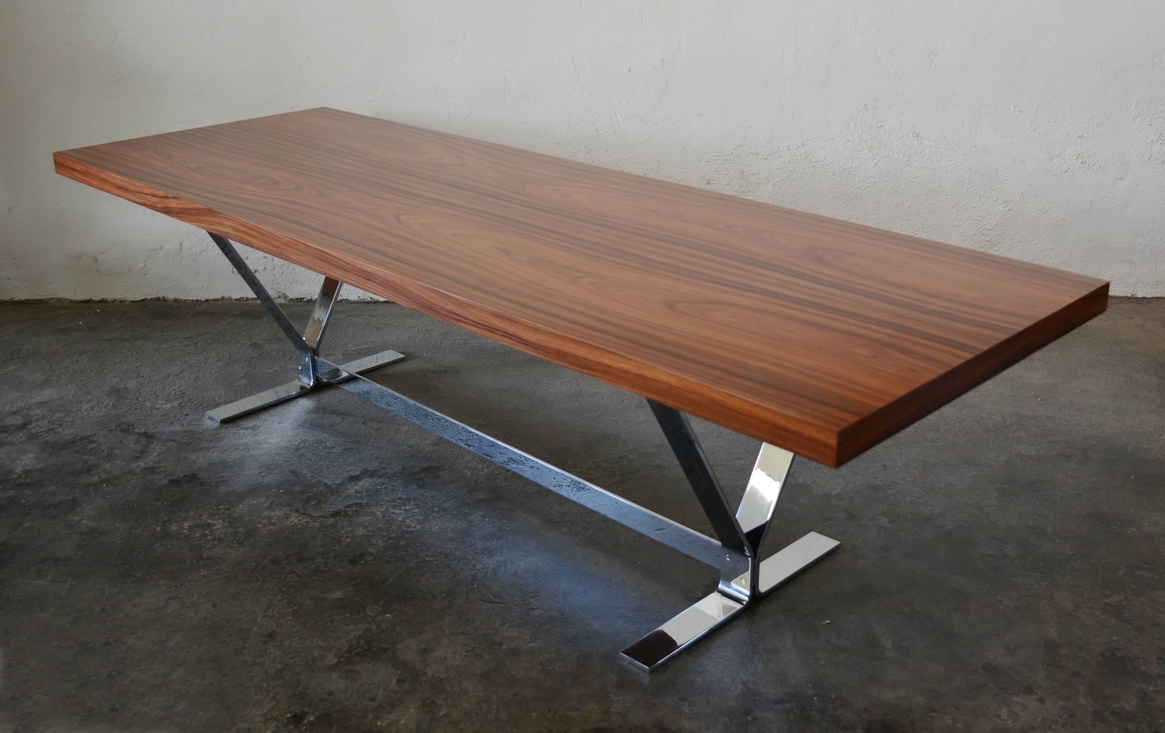 The richly grained rosewood top of this coffee table rest on an architectural chrome flat steel base. Contact us for cheaper shipping rates for California delivery.