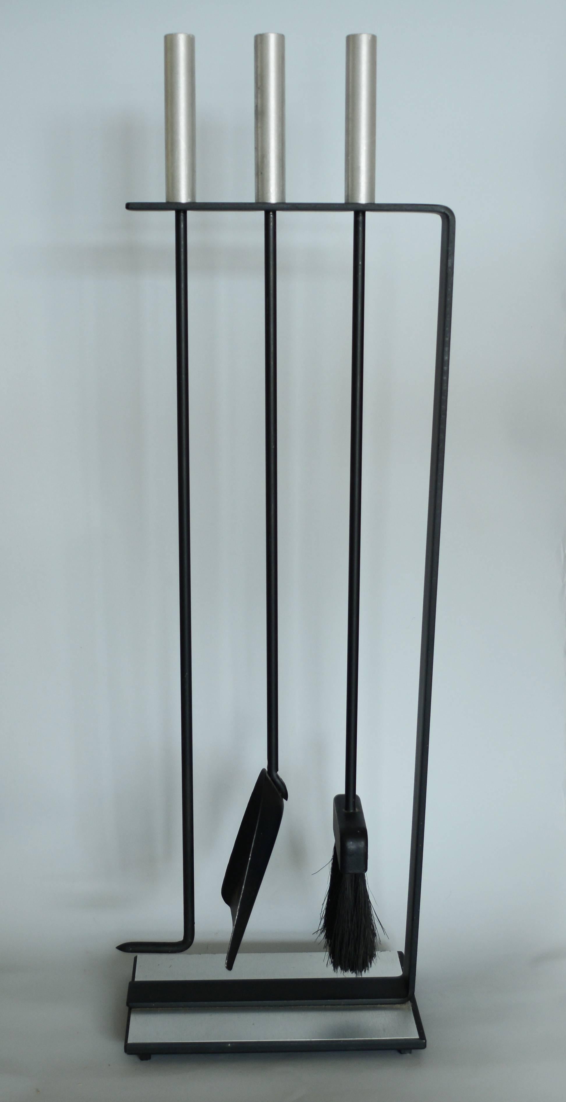 A Minimalist and clean lined set of fireplace tools by Pilgrim. These feature aluminum handles and a sheet of aluminum on the base. The set consist of a poker, dust pan and broom.