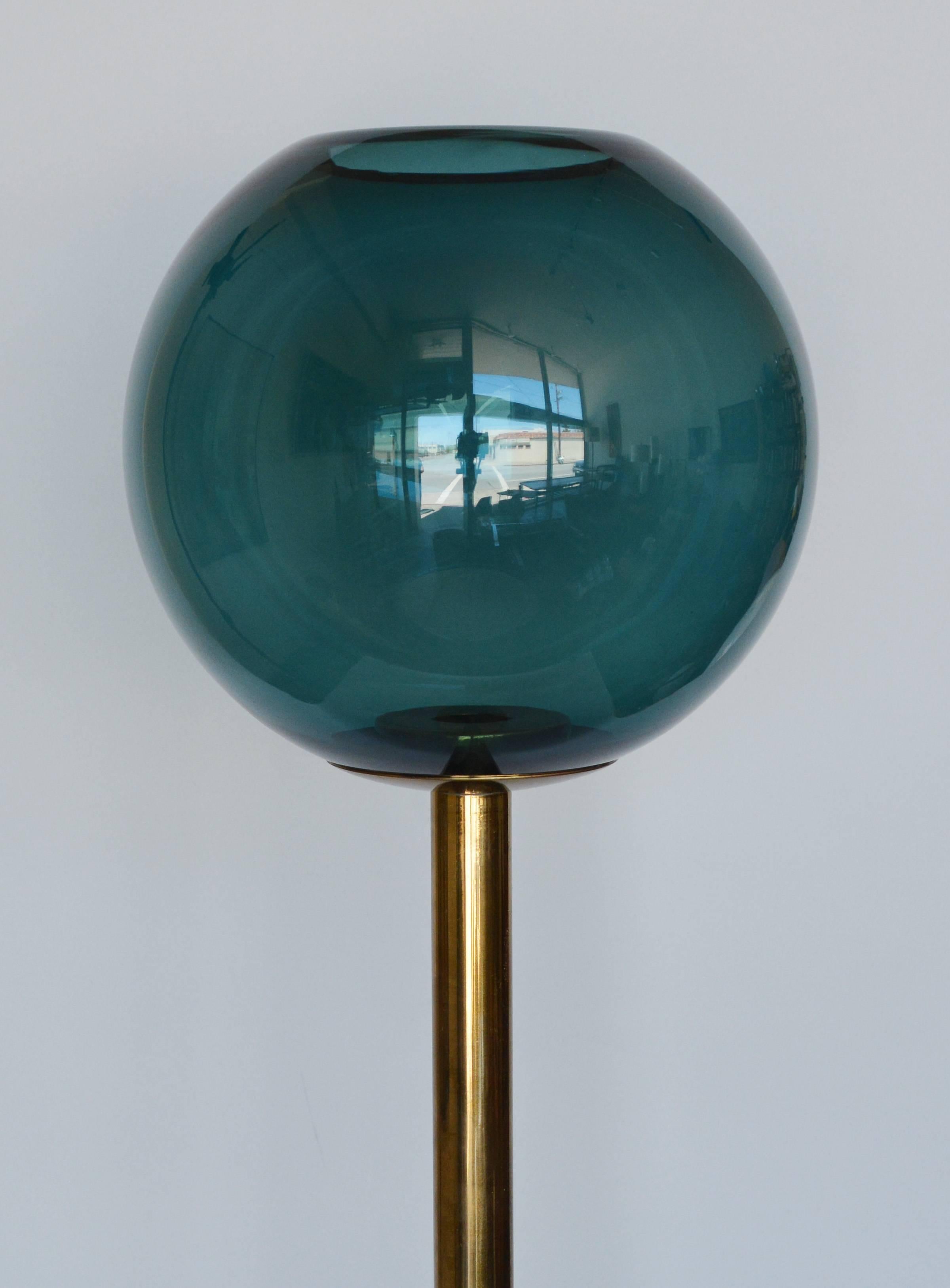 Brass candleholder with a glass globe by Hans Agne Jakobsson. There is a small chip on the rim of the glass and a slight bend in the brass where the globe rests.