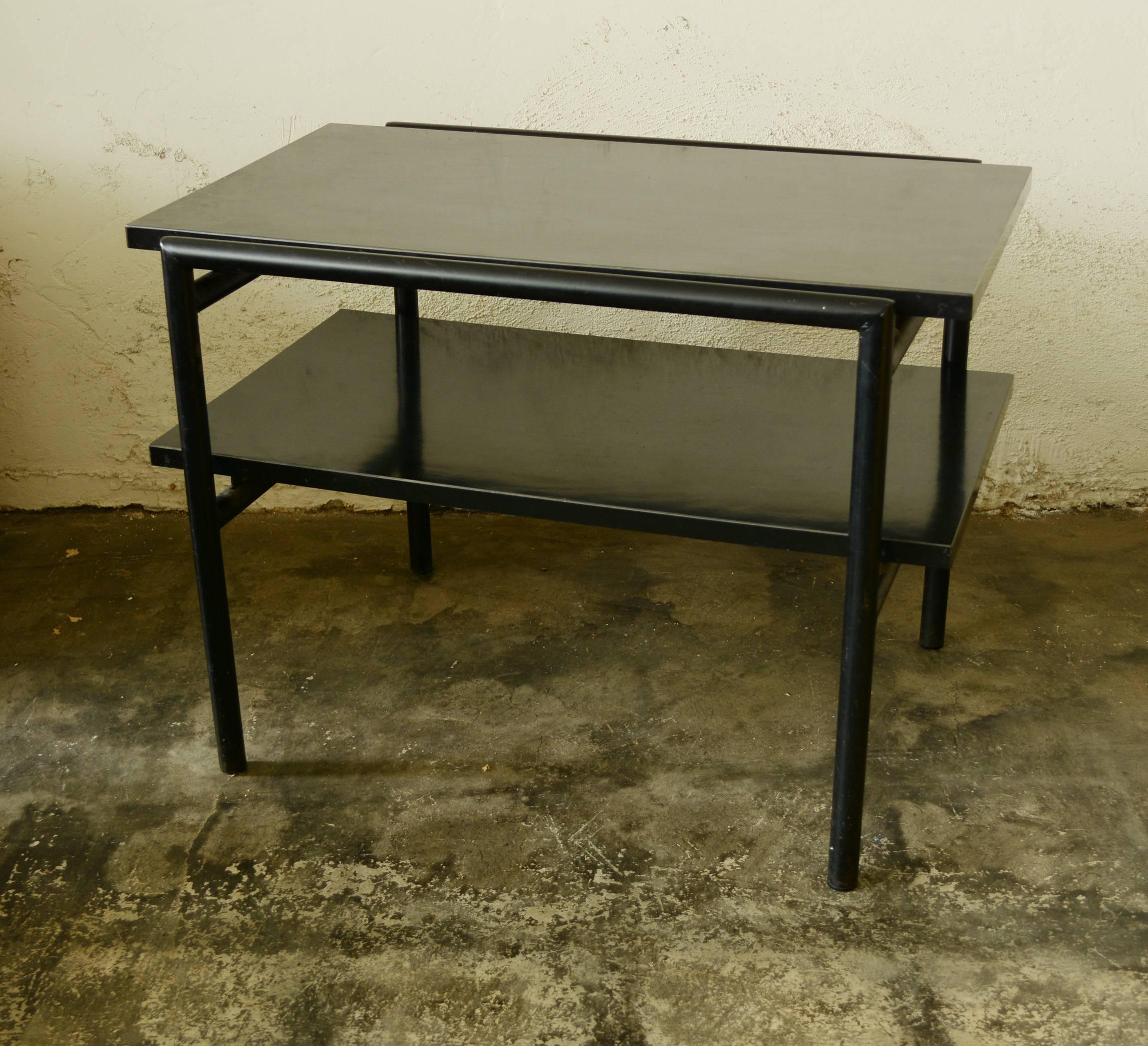 Side table designed by architect Donald Knorr for Vista. This table has a tubular steel frame with black laminate top and shelf. The table is in original condition. There are some scratches to the top and paint. One horizontal tube has had the paint