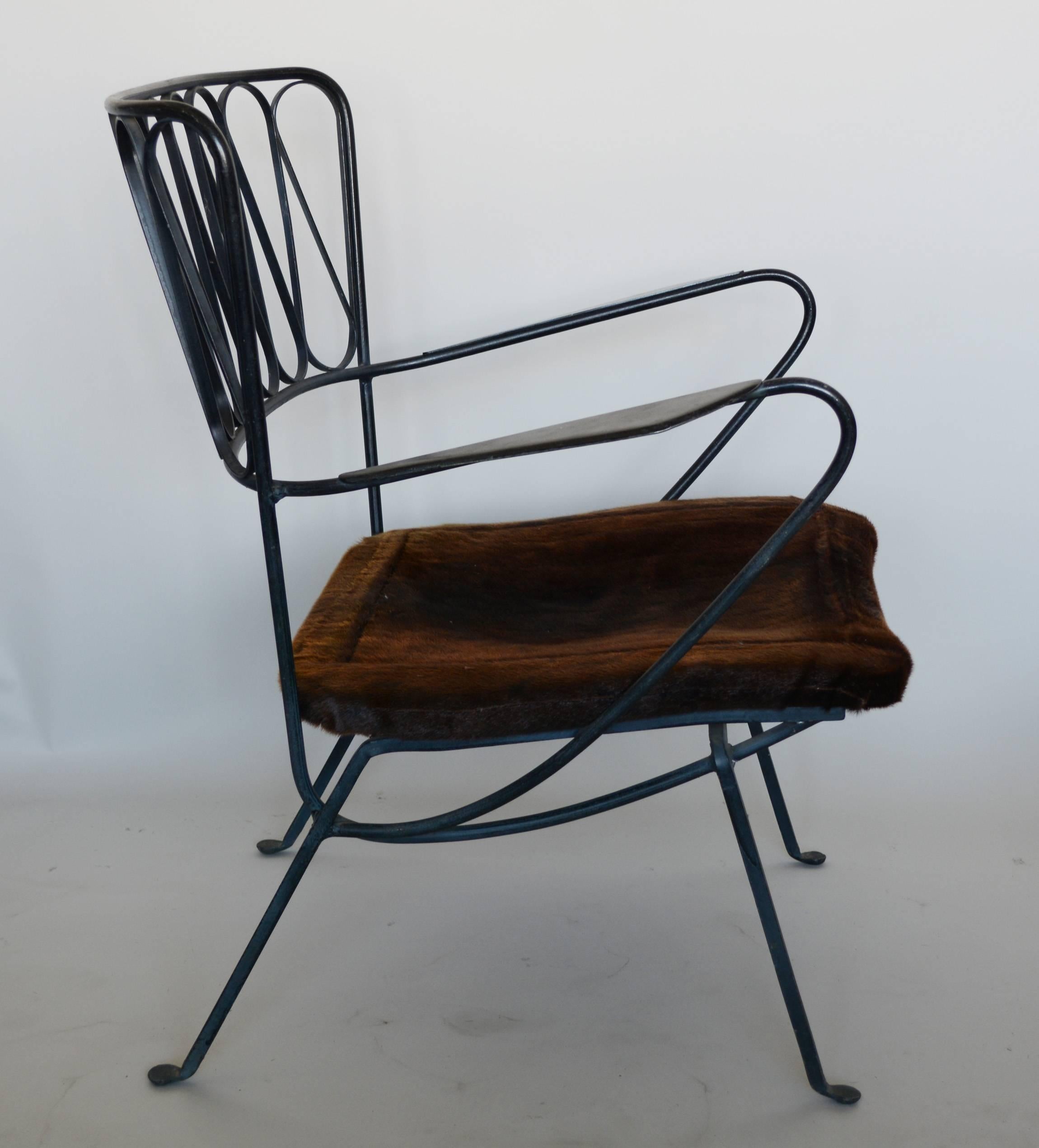 Ribbon back lounge chair with ottoman designed by Maurizio Tempestini.
The seat and ottoman top have an open wood frame with a leather sling attached. The leather was covered with mink at some point. The iron frame is original, there is some wear