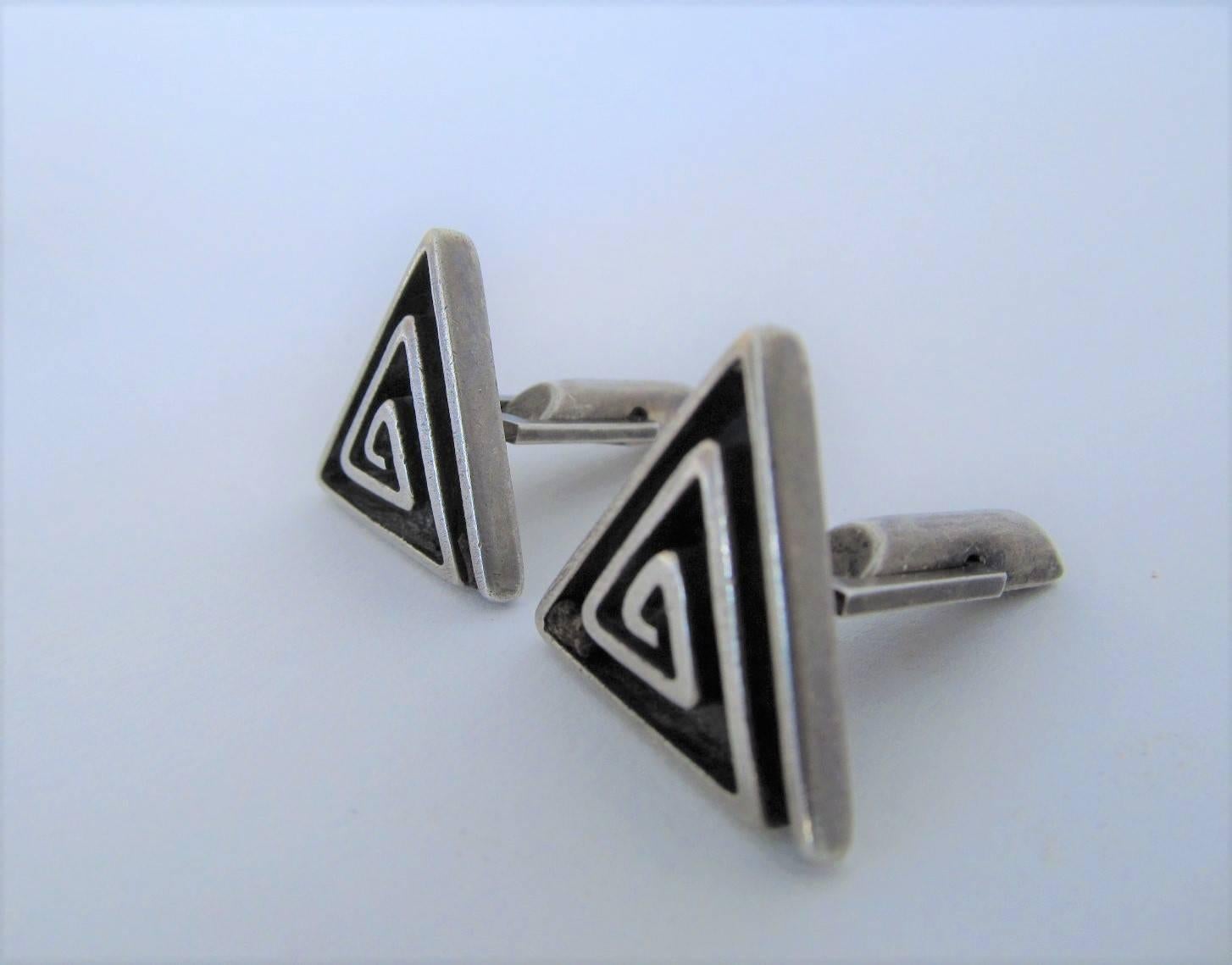 Understated but distinctive design by one of the most important Navajo jewelry makers. A variation on one of his recurring design patterns, the spiral of life. 

Kenneth Begay is considered the father of modern Navajo jewelry. Like so many