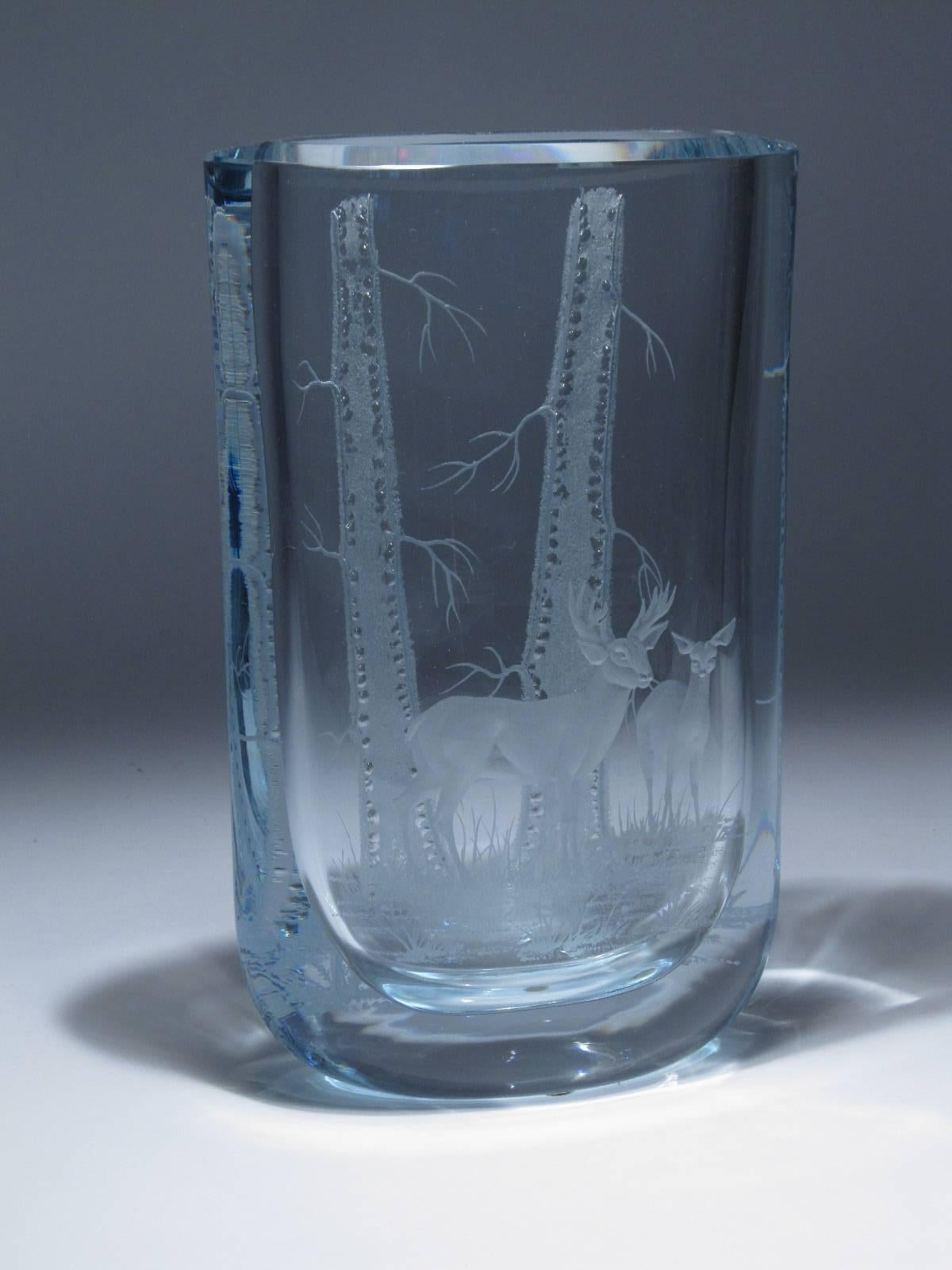 A masterful execution in this beautiful and large piece of Swedish art glass from Strombergshyttan Glass Company. On the front side are two deer standing in the grass, at the forest edge, and on the back side are two tall trees. The juxtaposition of