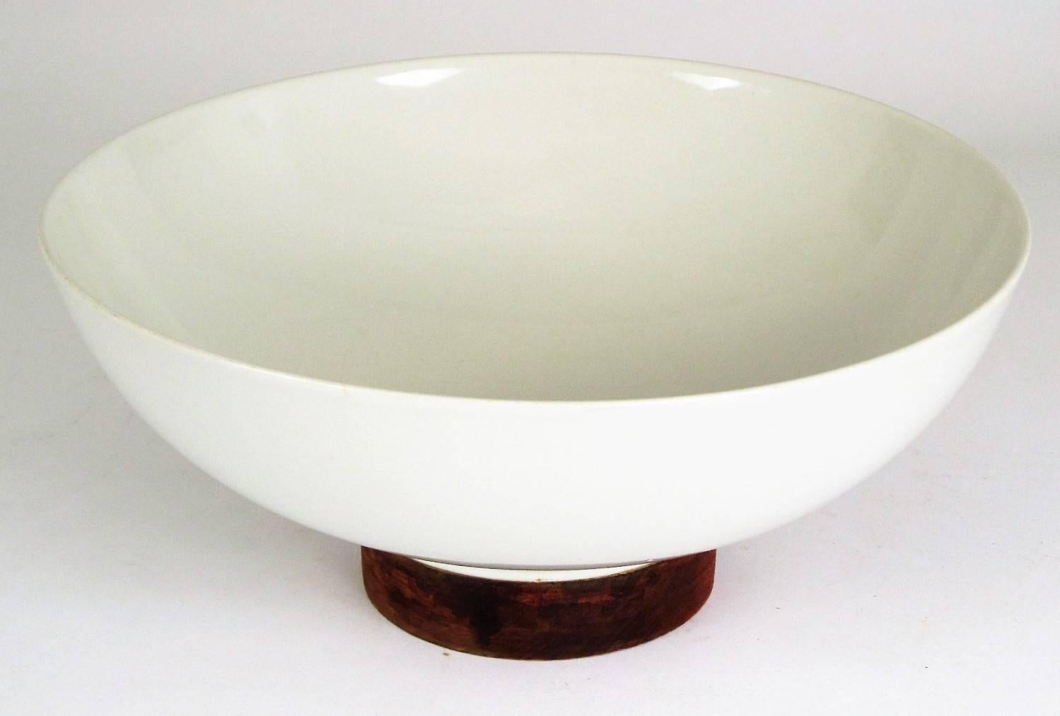 Designed in 1955 for Raymor and manufactured by Hyalin ceramics company. Each piece is white porcelain with walnut accents. All are in excellent condition with the exception of the large salad bowl which has some minor crazing to the interior. The