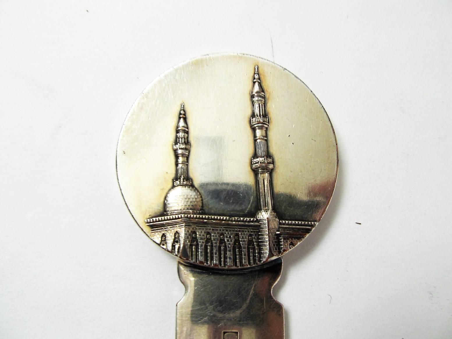 This piece seems to harken back to the French colonial period, perhaps from the 1930s through the 1950s. On one side are two minarets in relief and on the opposite side a desert palm and two crossed swords. No inscription except the makers mark.