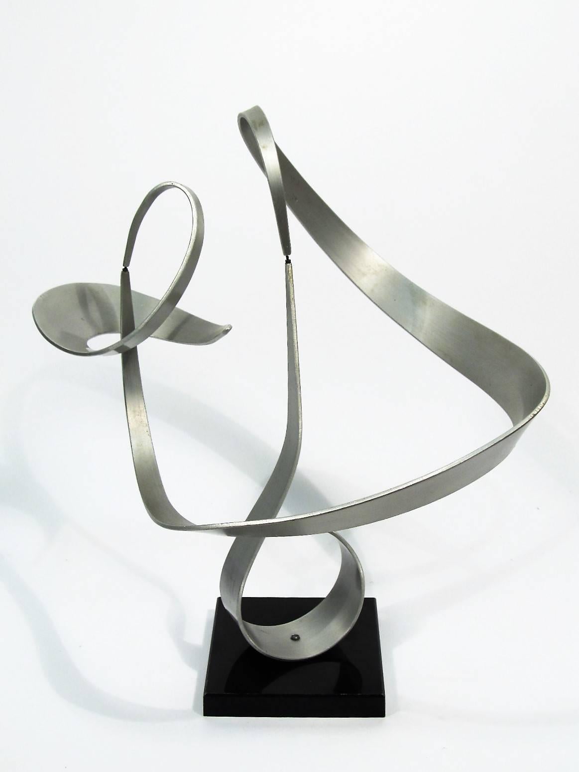 This is an ingenious and beautiful sculpture composed of three elements that interlock and balance, forming a fluid and dynamic line that even a gentle breeze will set in motion.