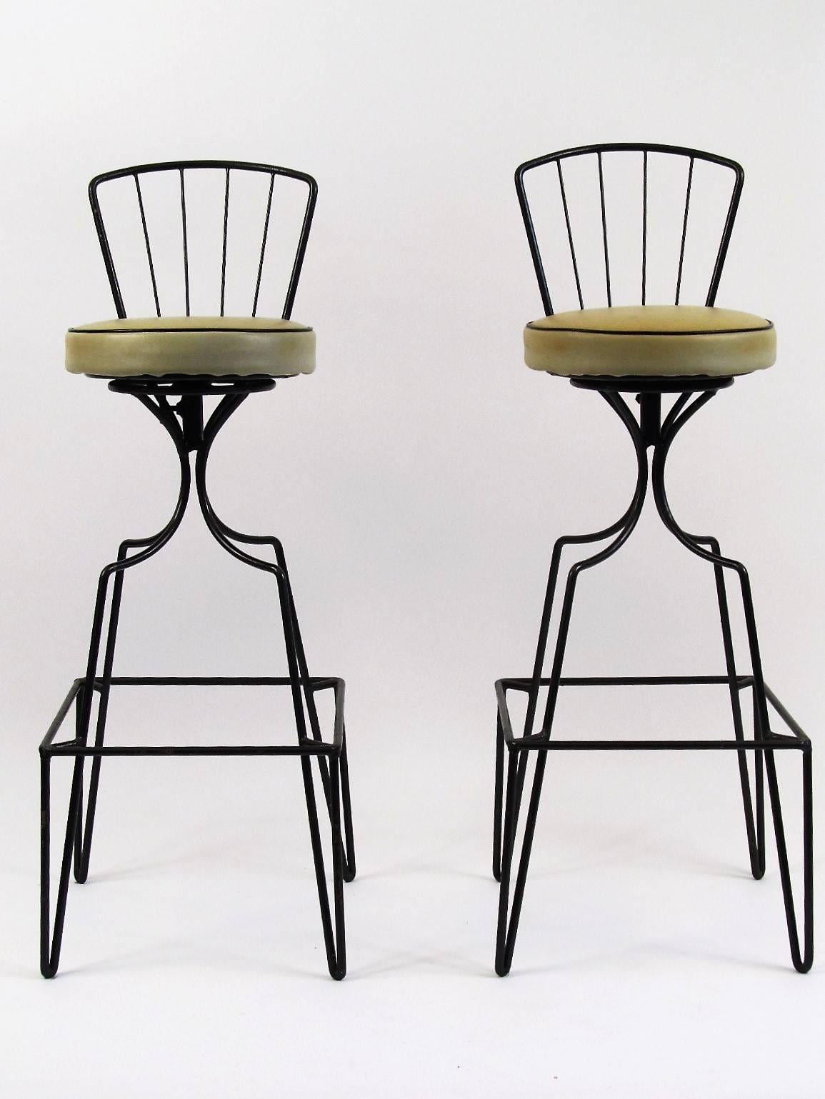 A distinctively 1950s look, this pair of bar stools would work well with any 1950s bar. The seats rotate smoothly and the upholstery appears to be original and in good condition.