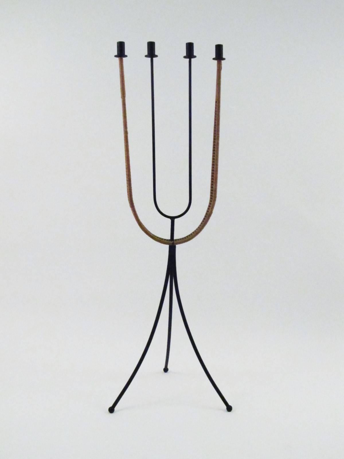I find this to be one of Arthur Umanoff's most elegant designs. Big dramatic shapes and curves and the wonderful contrast of the hard black lines of iron with the organic delicacy of the wicker rapping.

Three plastic ball feet.