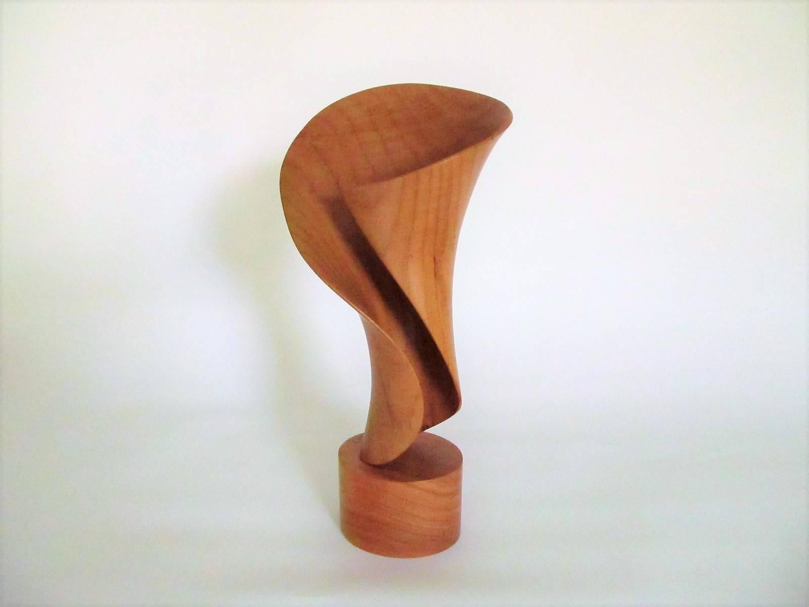 An organic and sensuously pleasing wood sculpture by California artist John McAbery, done in 1999. 

McAbery lives on a remote beach in Northern California in his hand made house and creates fantastic wood sculptures entirely by hand, using only
